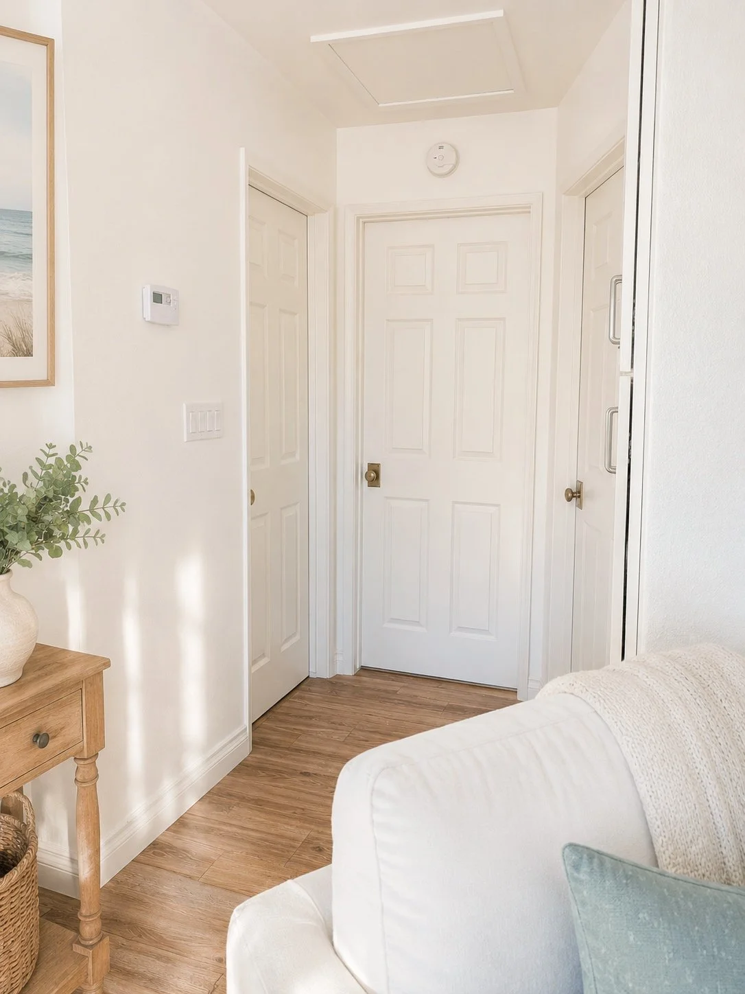 Bright hallway featuring upgraded brass door knobs in a beautifully renovated home.