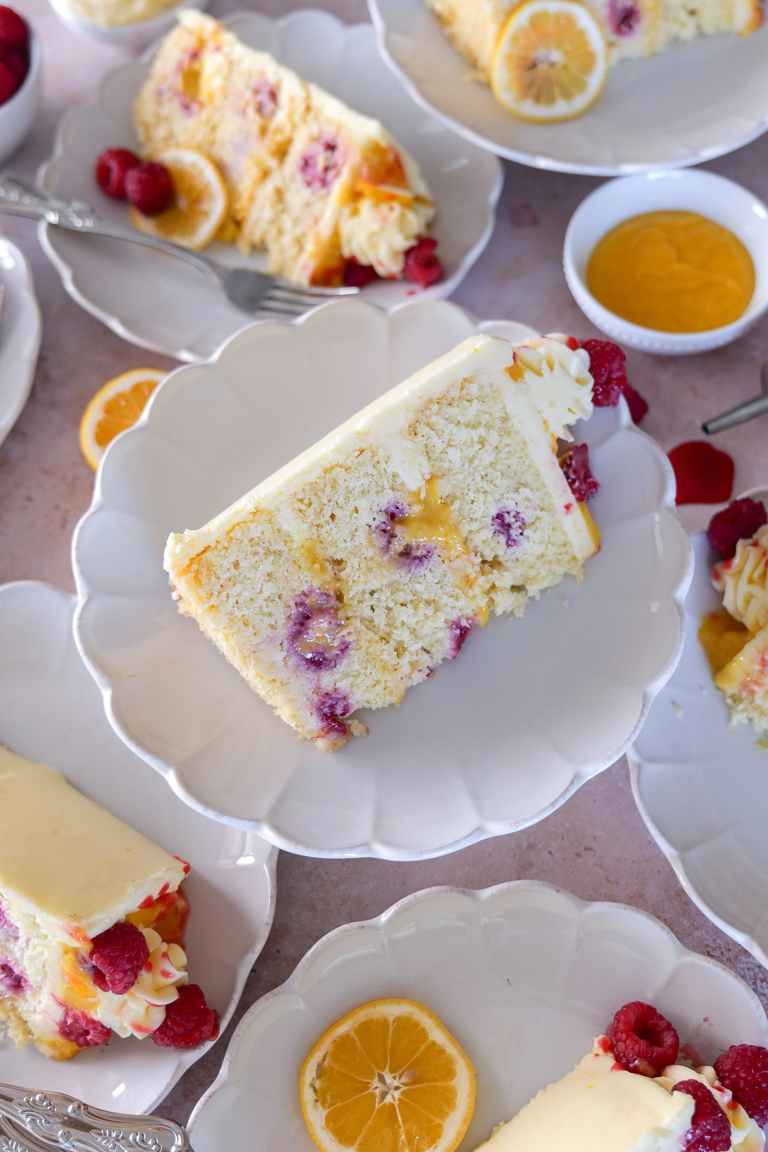 Lemon curd layer cake with fresh raspberries and fluffy frosting.