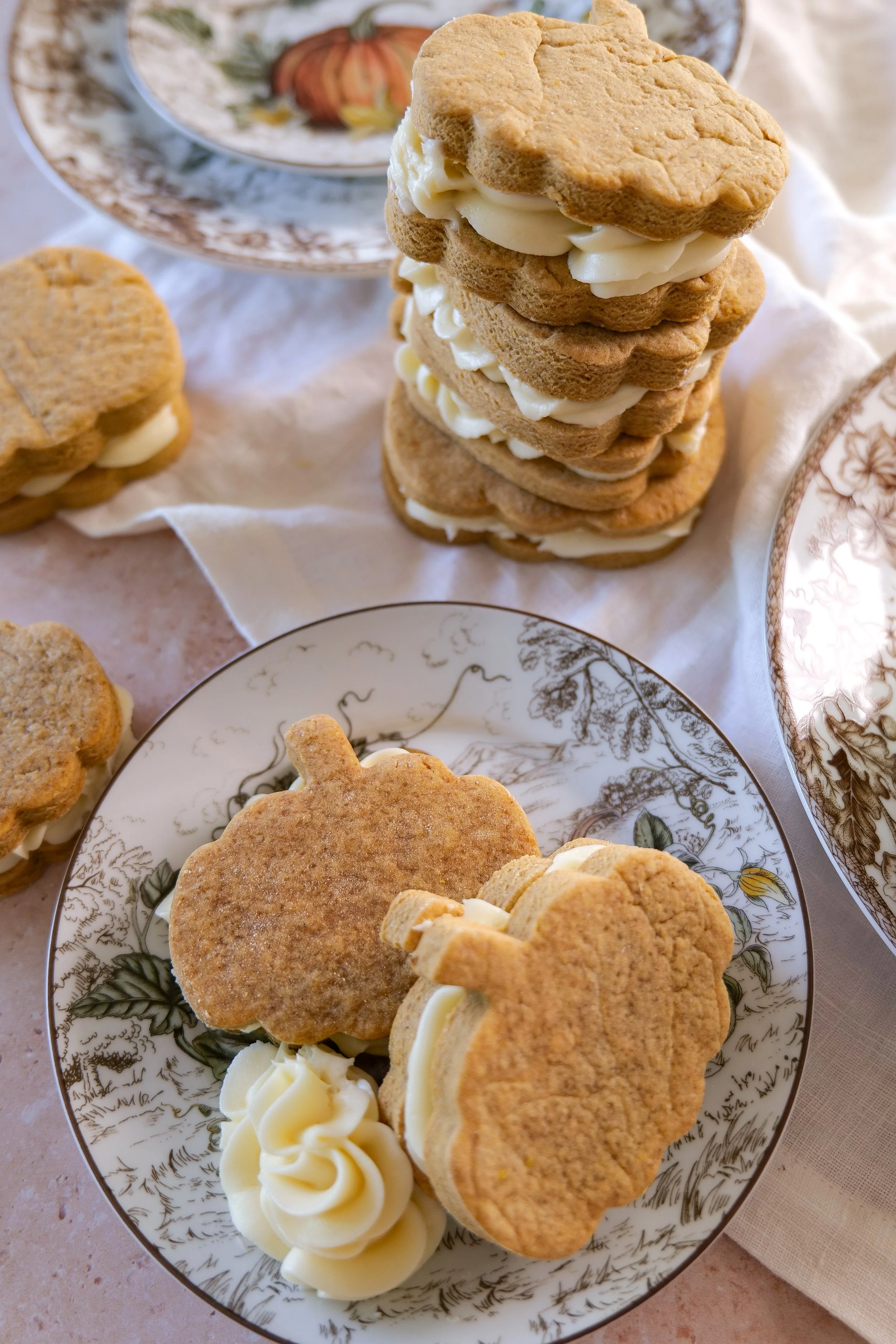 Brown butter pumpkin sandwich cookies with cream cheese filling stacked for fall baking
