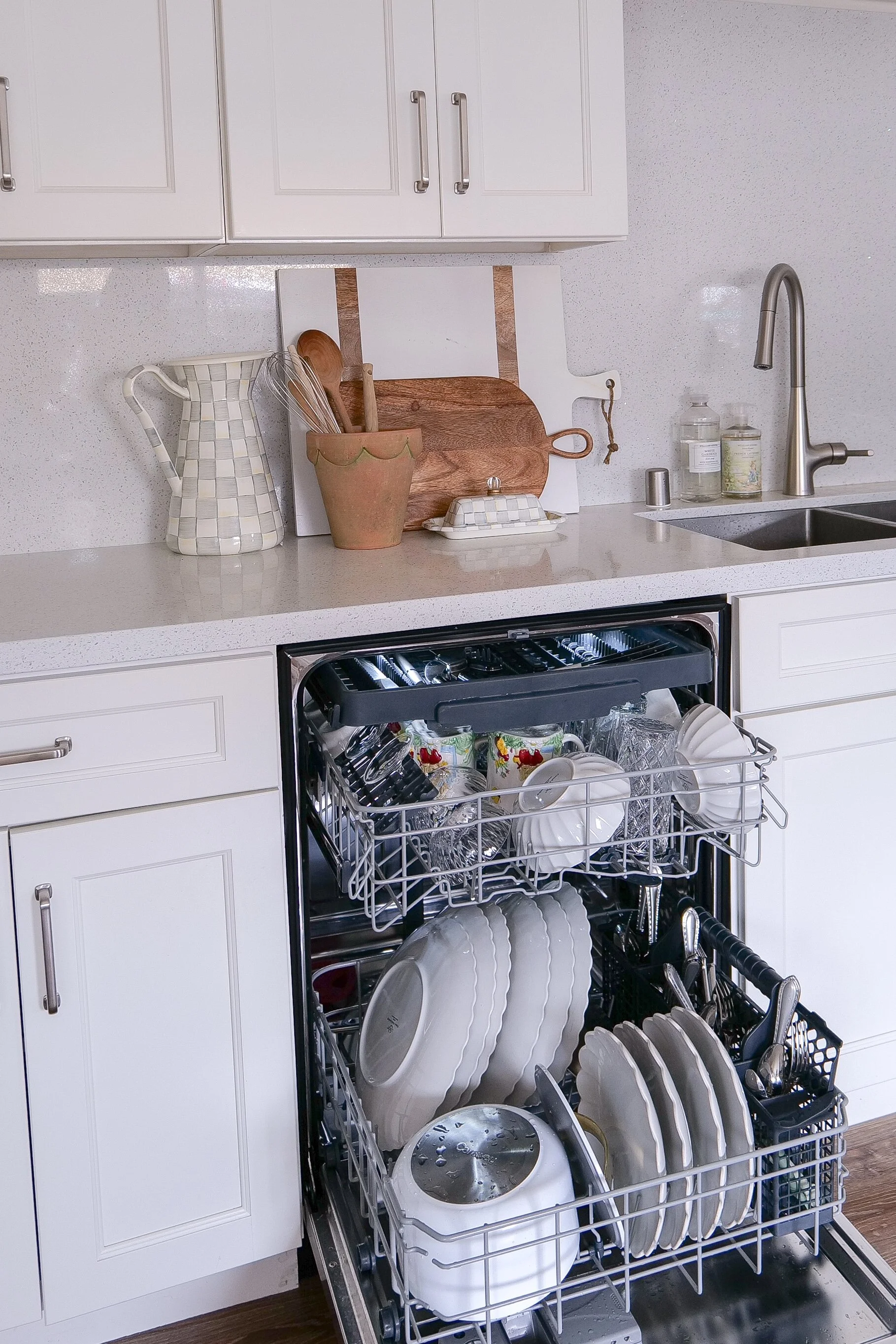 Dishwasher utensil basket neatly organized with forks, spoons, and knives separated.