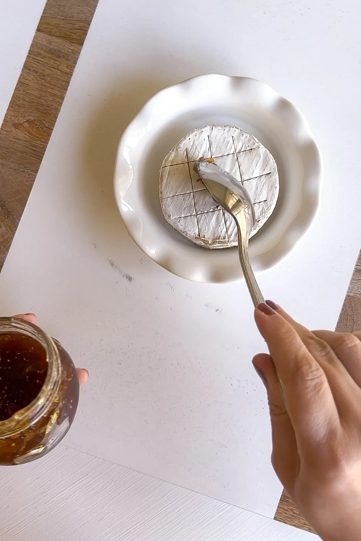 Adding fig jam to warm baked Brie