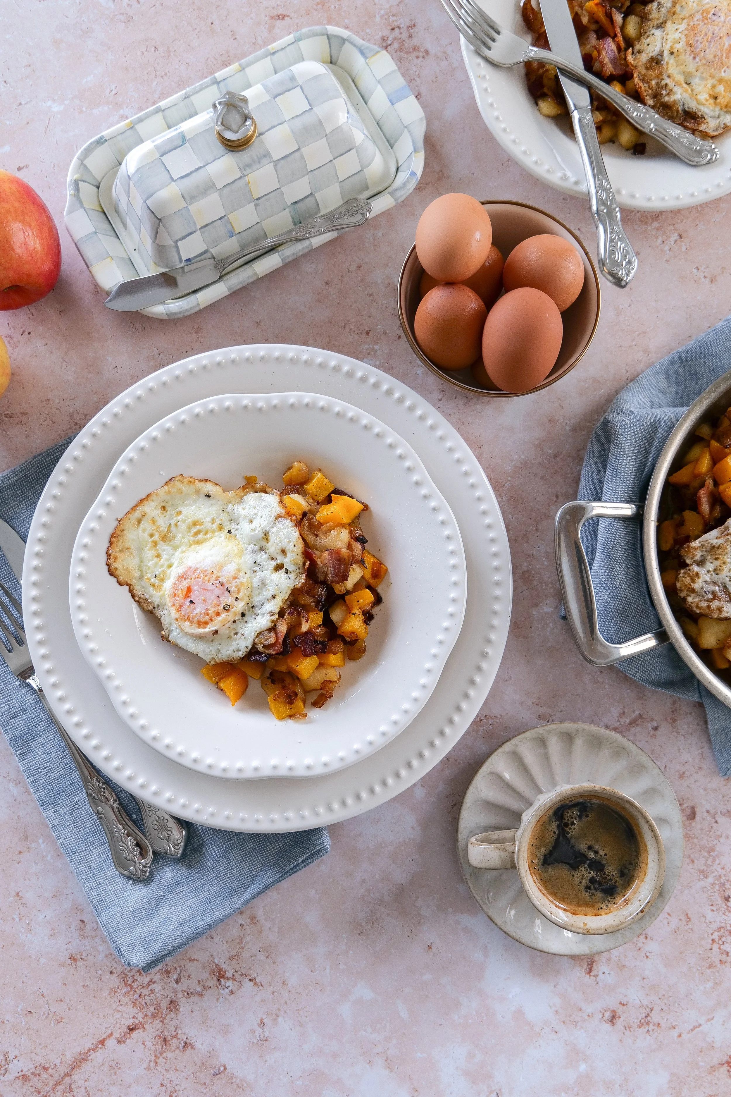 Fall breakfast hash topped with fried eggs and filled with roasted squash, apples, and bacon.