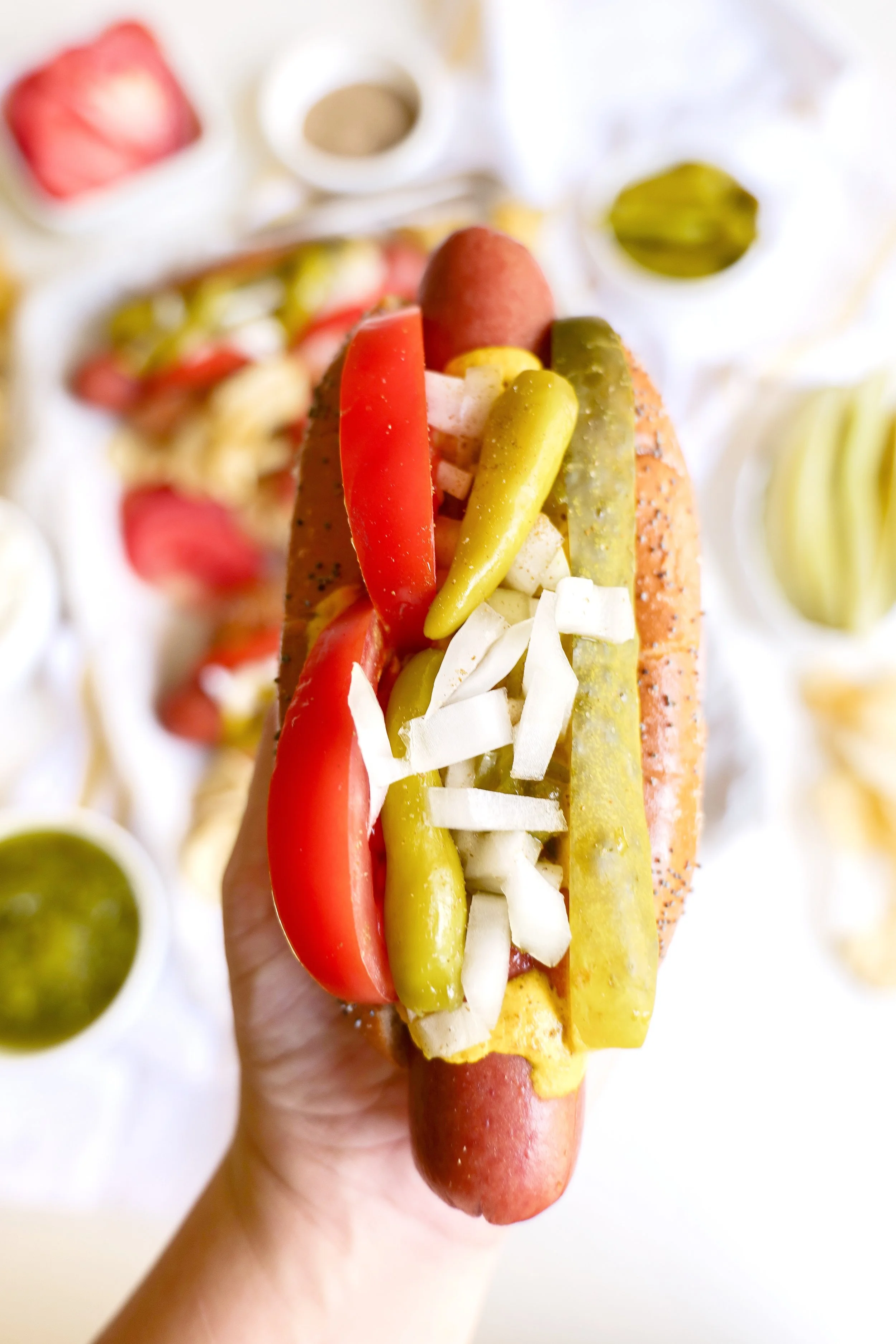 Authentic Chicago style hot dog topped with pickles, tomatoes, relish, peppers, onions, mustard, and celery salt.