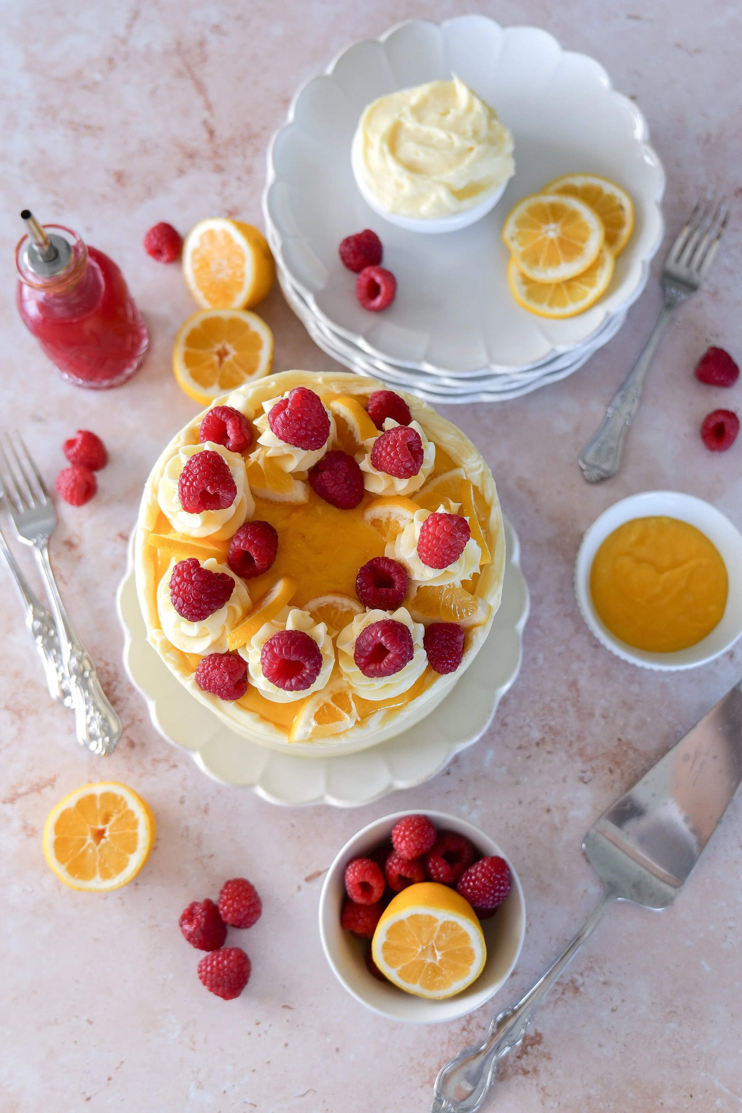 Bright lemon raspberry cake decorated with fresh berries and lemon zest.
