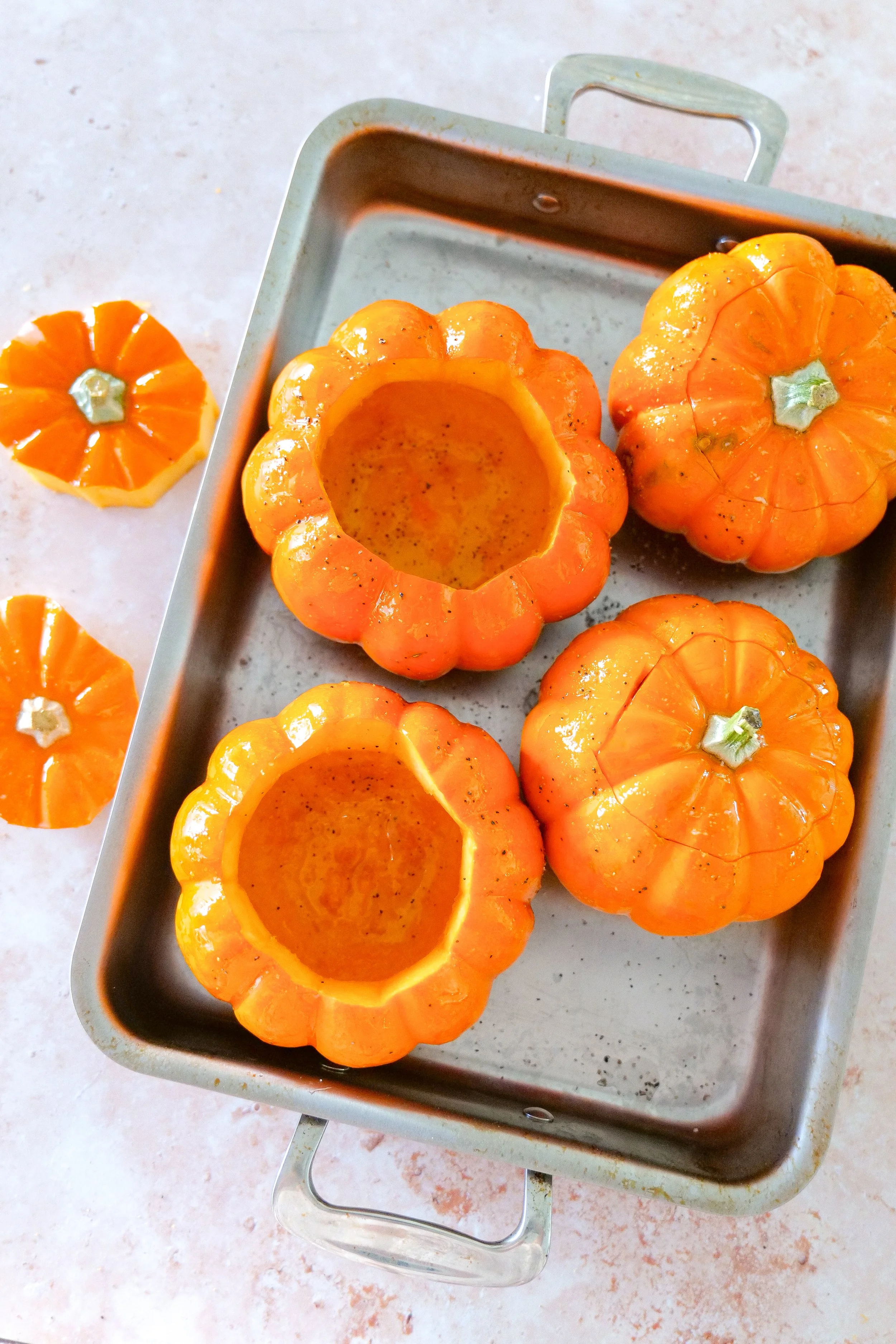 Small pumpkins with the tops removed and centers cleaned out before roasting and stuffing.