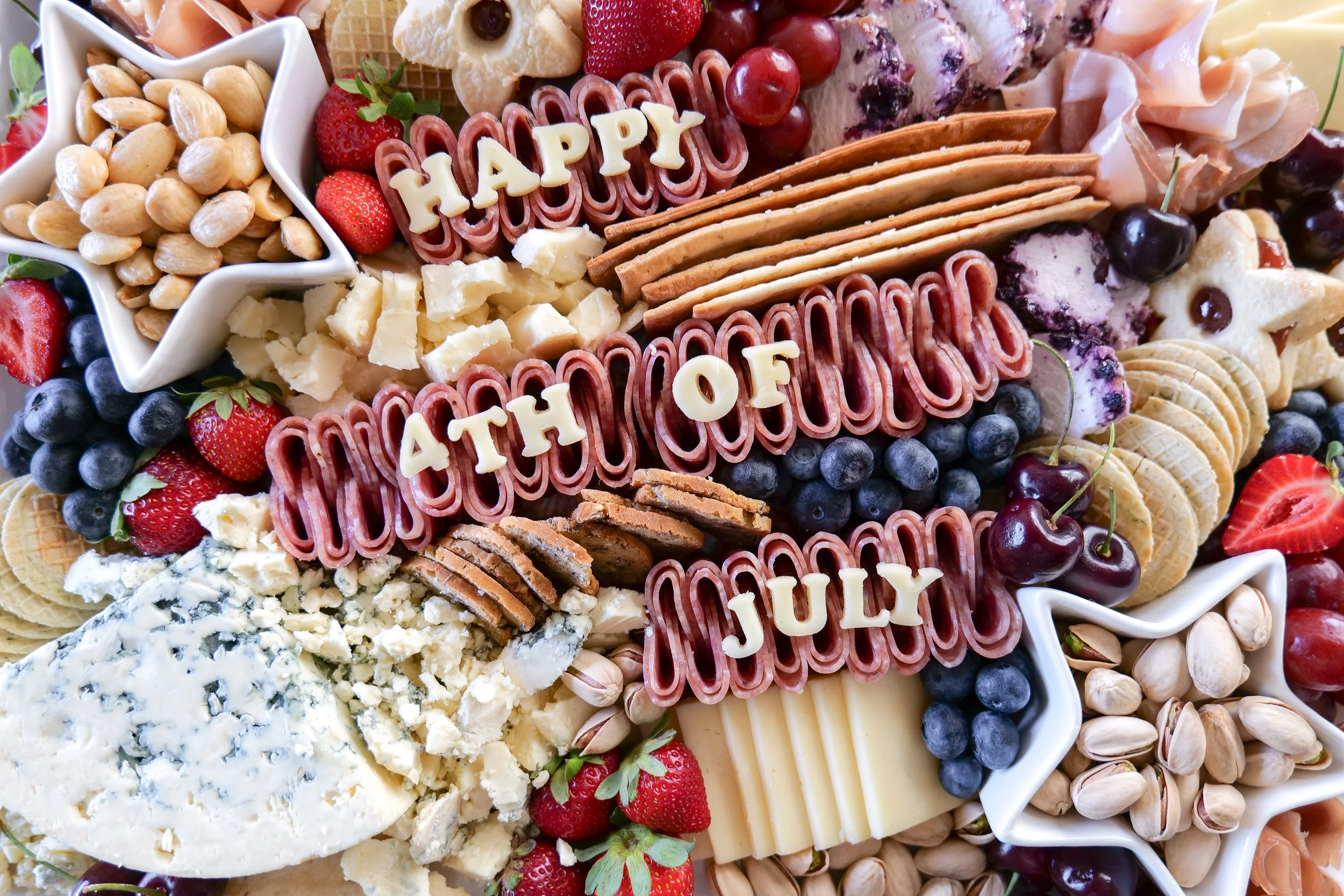 Charcuterie board for a summer party featuring colorful seasonal ingredients.