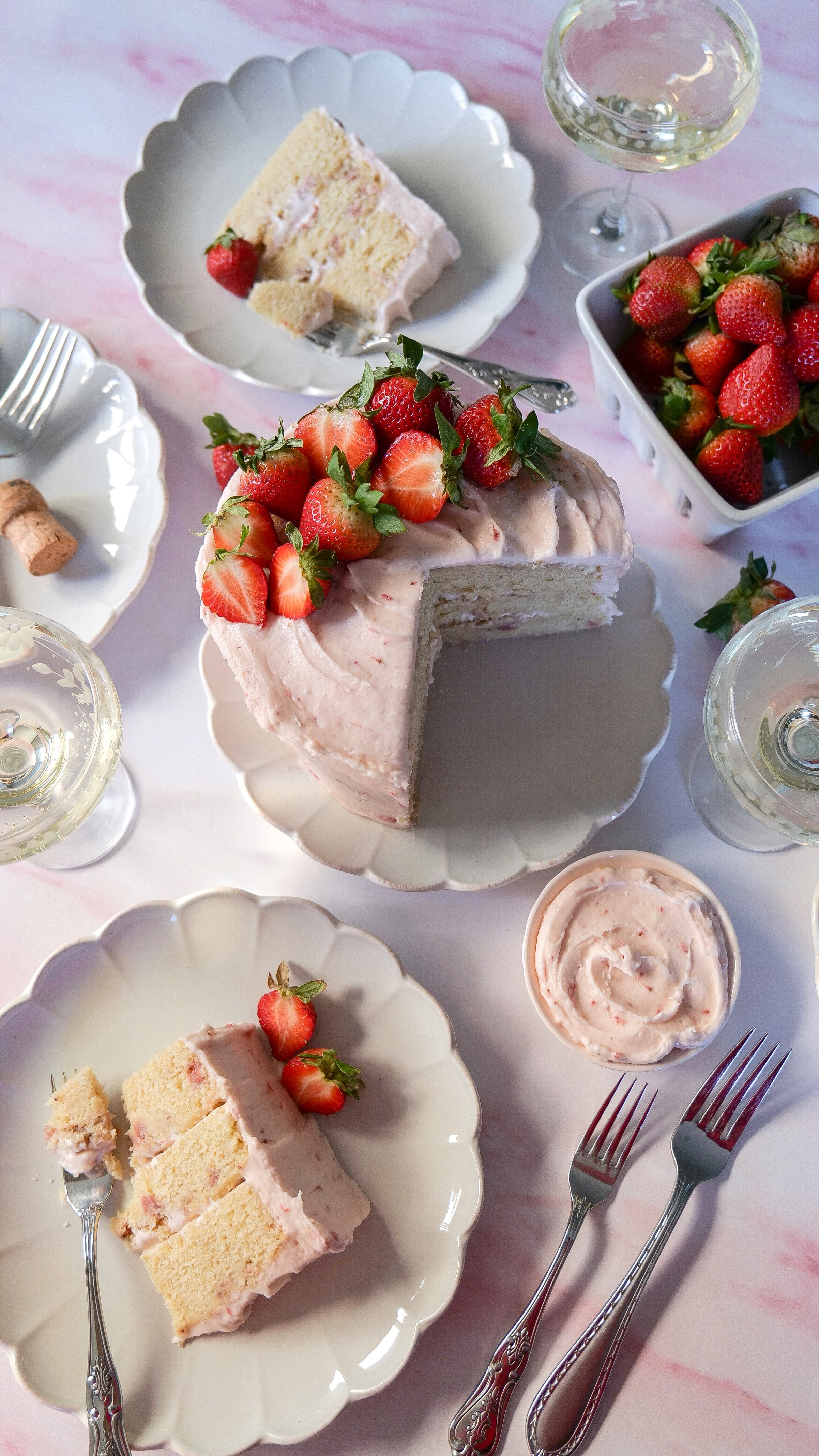 Layer cake covered in strawberry cream cheese frosting made with strawberry purée and champagne.