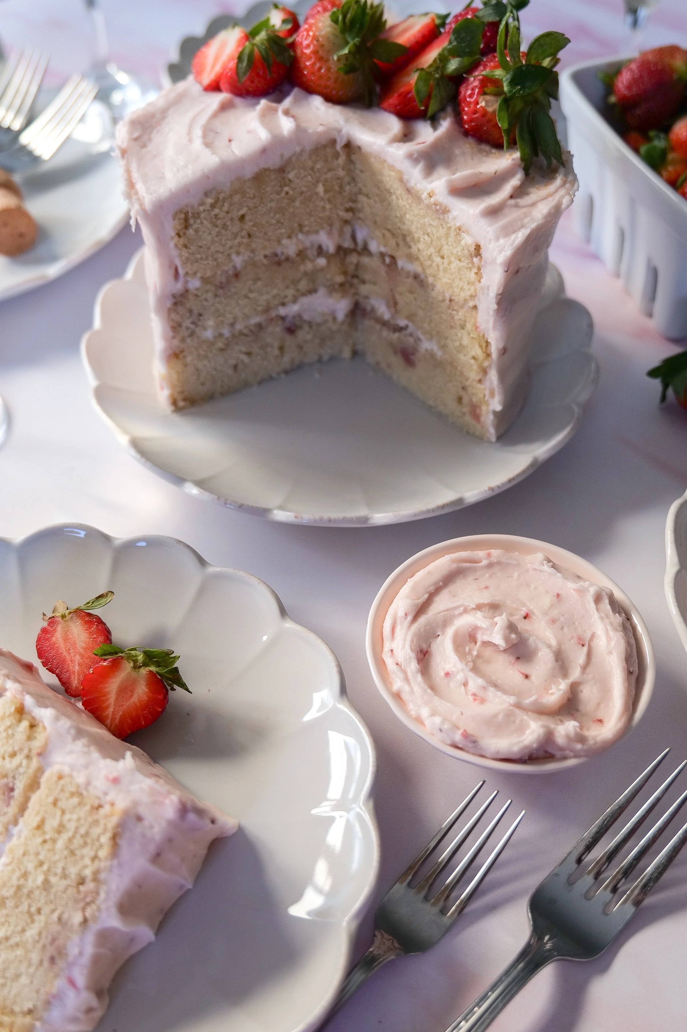 Three-layer strawberry champagne cake with soft cake layers and creamy pink frosting.