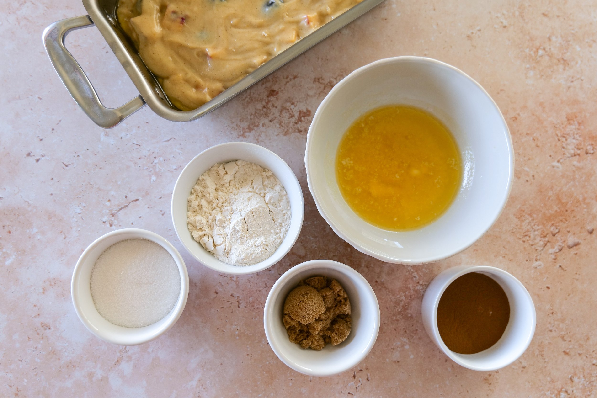 Loaf pans filled with Blueberry Peach Bread batter and cinnamon streusel before baking.