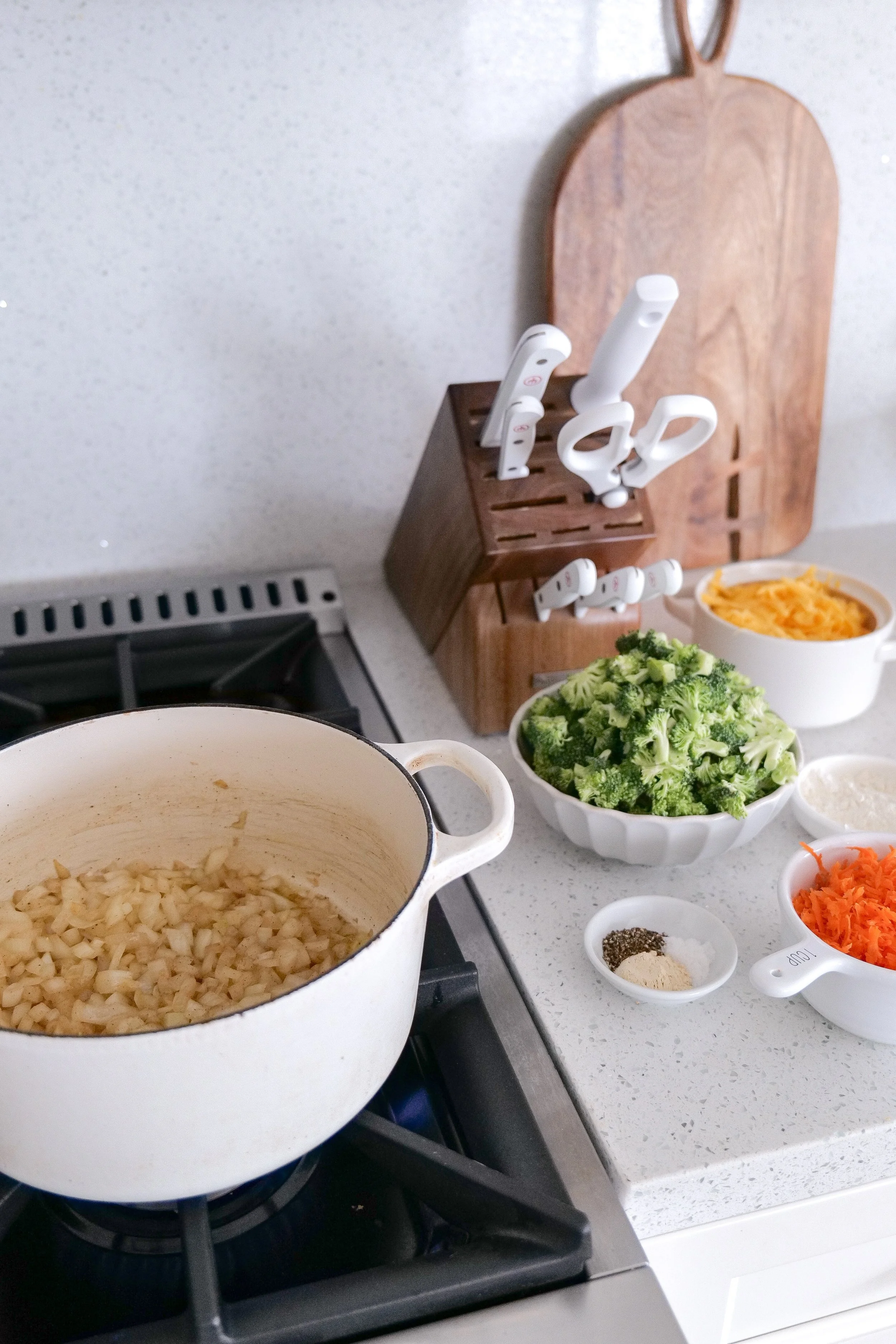 Fresh ingredients for homemade broccoli cheddar soup arranged in the kitchen.