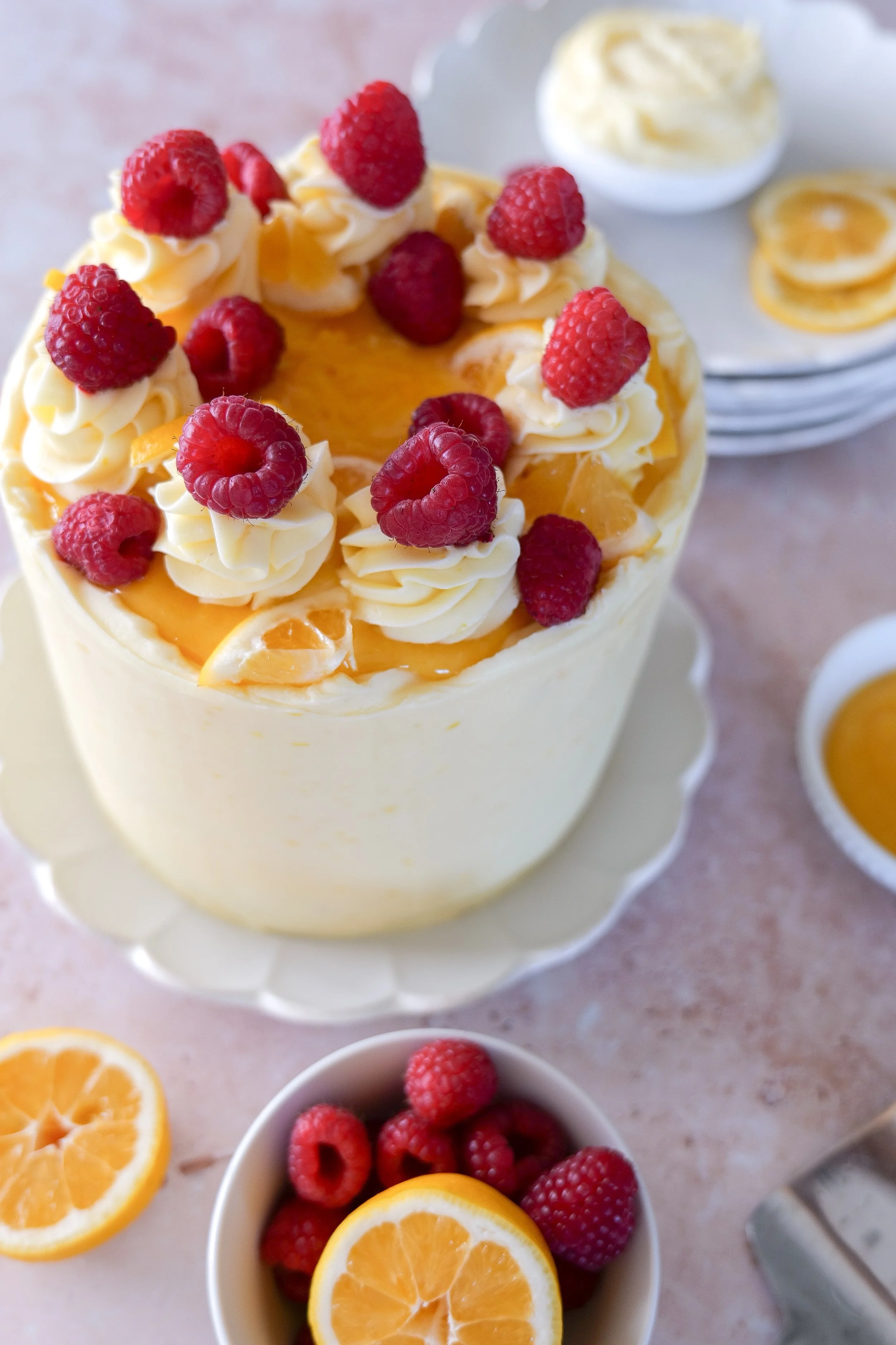 Elegant lemon raspberry cake decorated with berries and frosting.