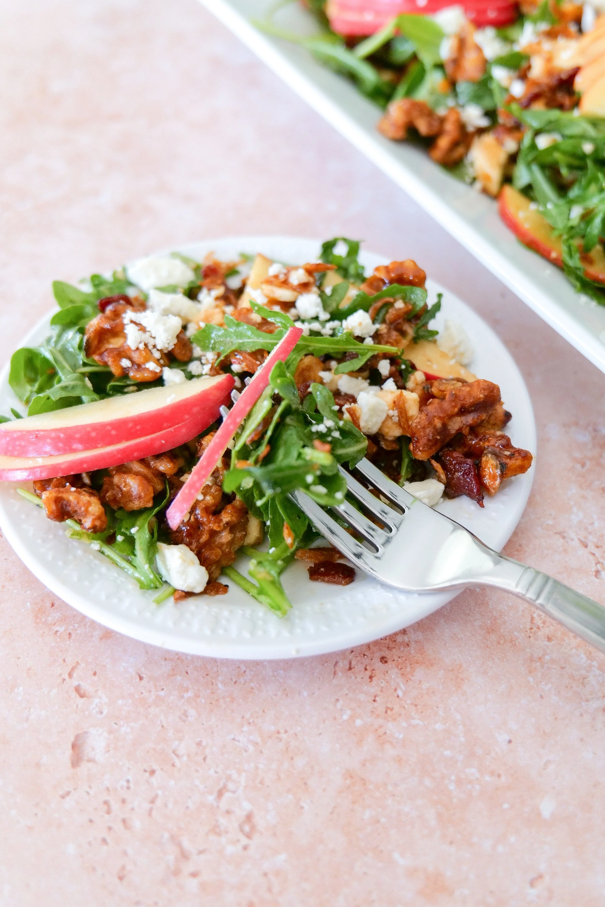 Fall salad topped with homemade maple walnuts, sliced apples, feta cheese and bacon.
