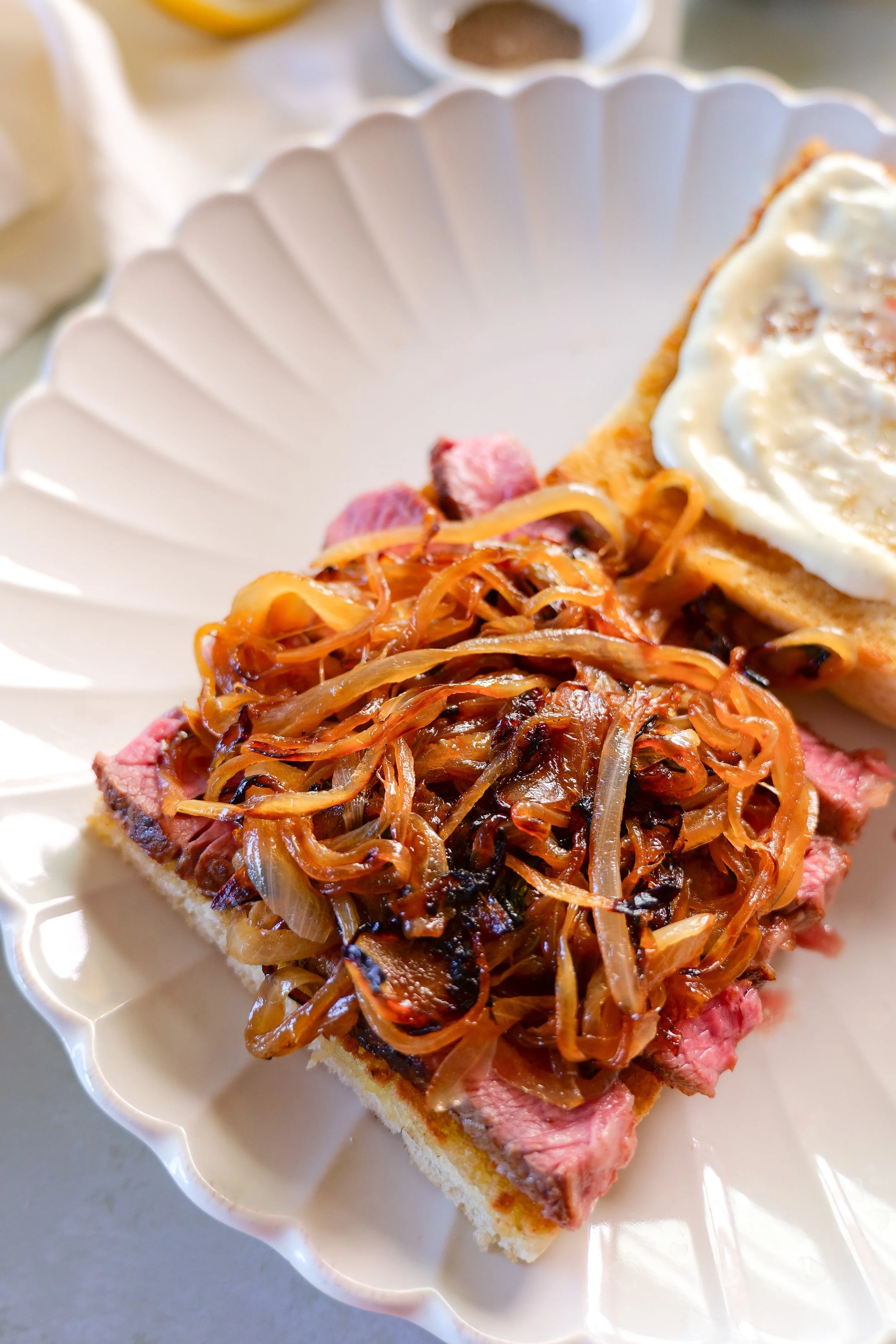 Toasted focaccia layered with sliced ribeye, caramelized onions and provolone cheese before serving.