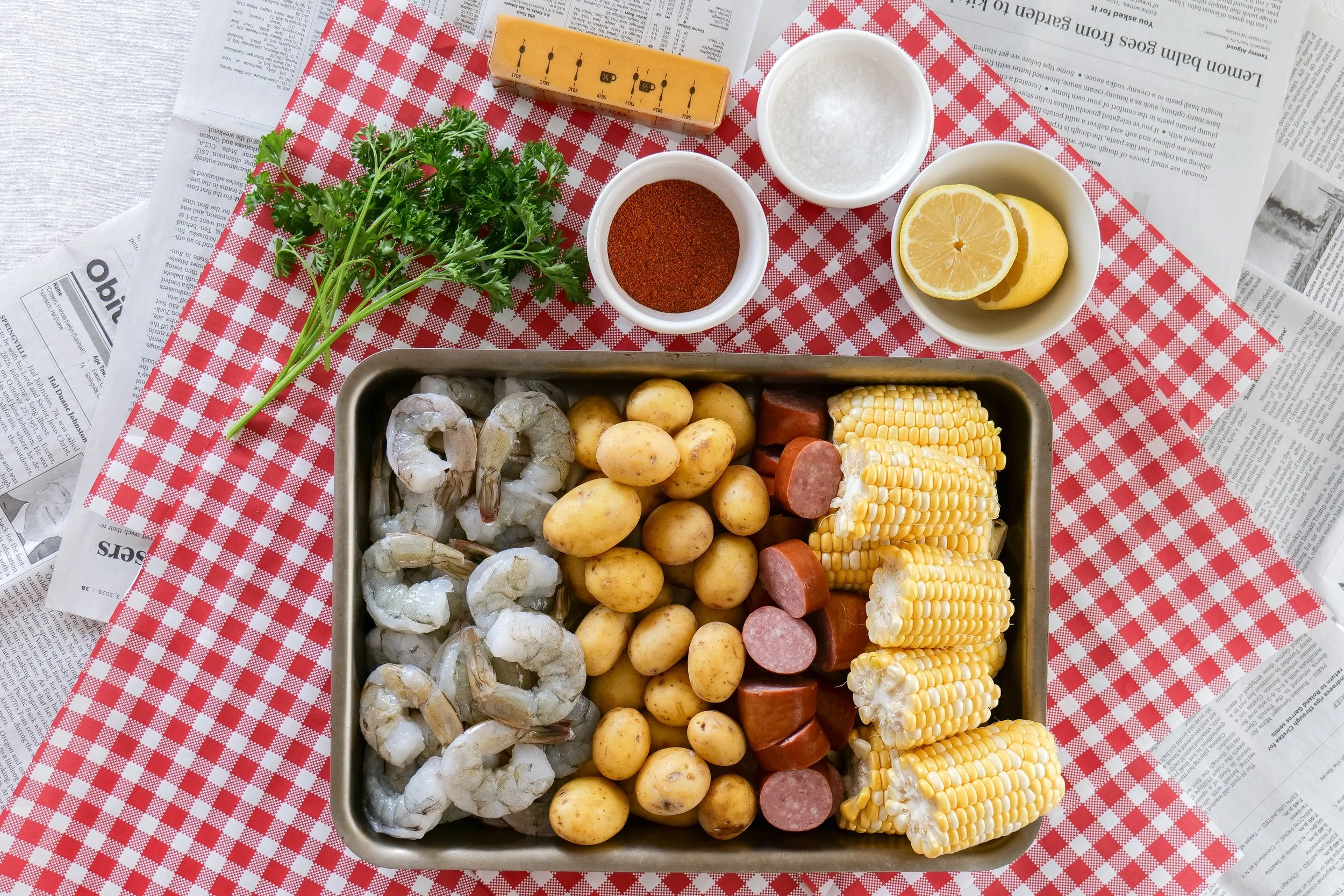 Shrimp boil with corn on the cob, smoked sausage, potatoes, and Old Bay seasoning.