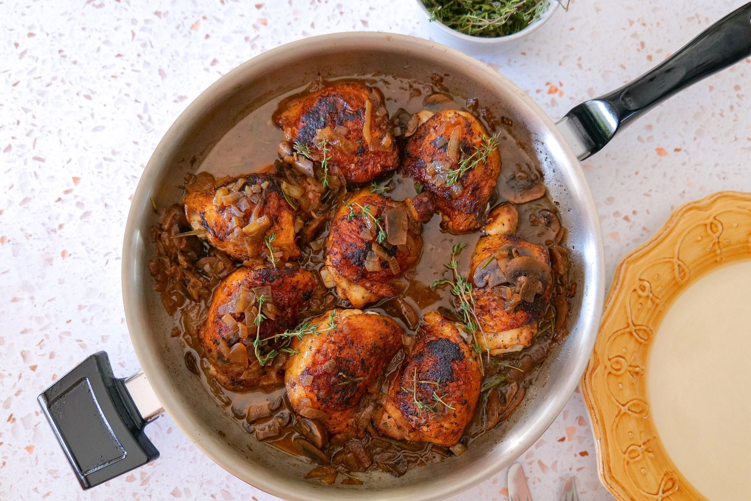 Savory skillet chicken thighs with golden skin, mushrooms and onions.