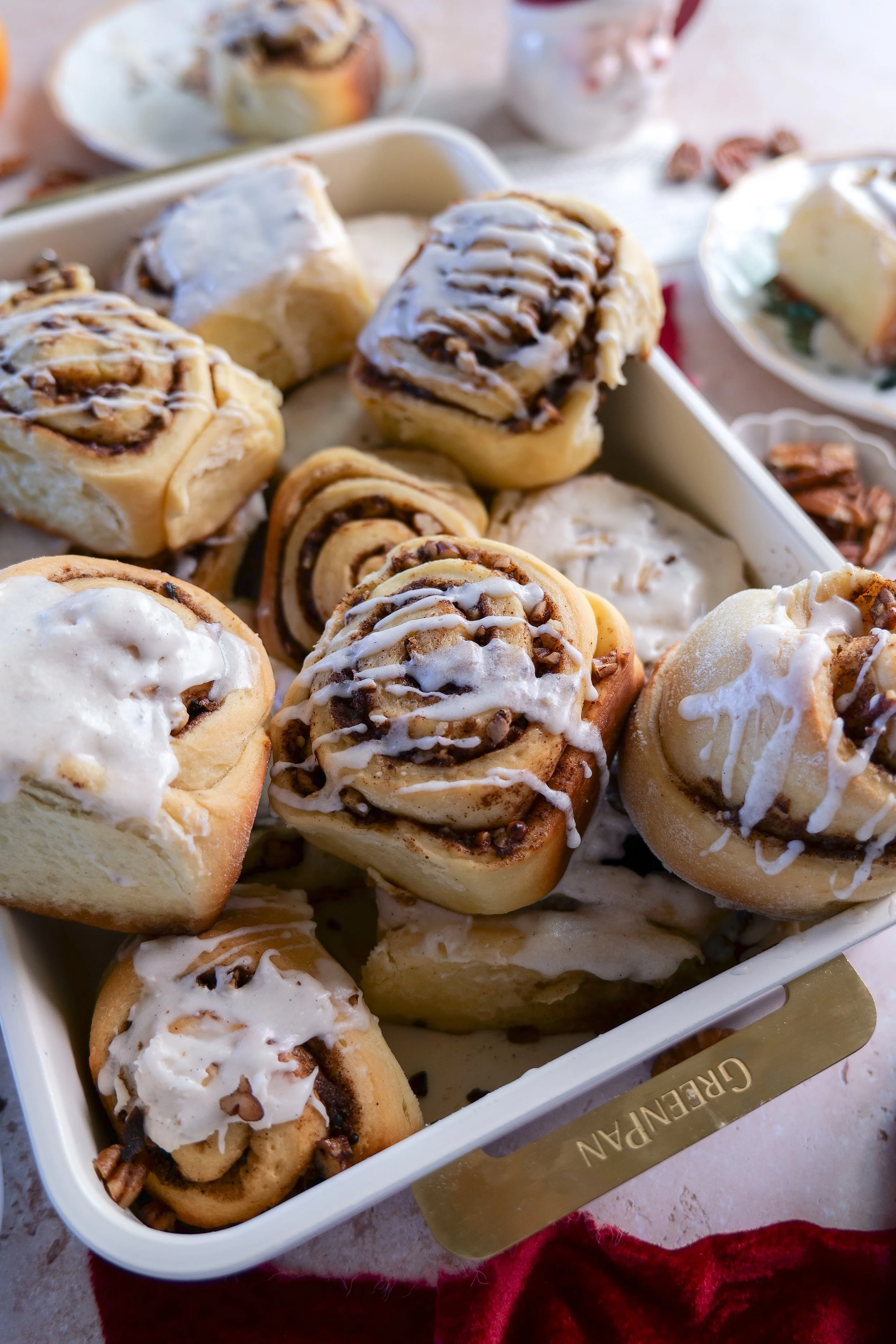 Homemade orange pecan cinnamon rolls with vanilla bean glaze ready to serve for Christmas morning breakfast.