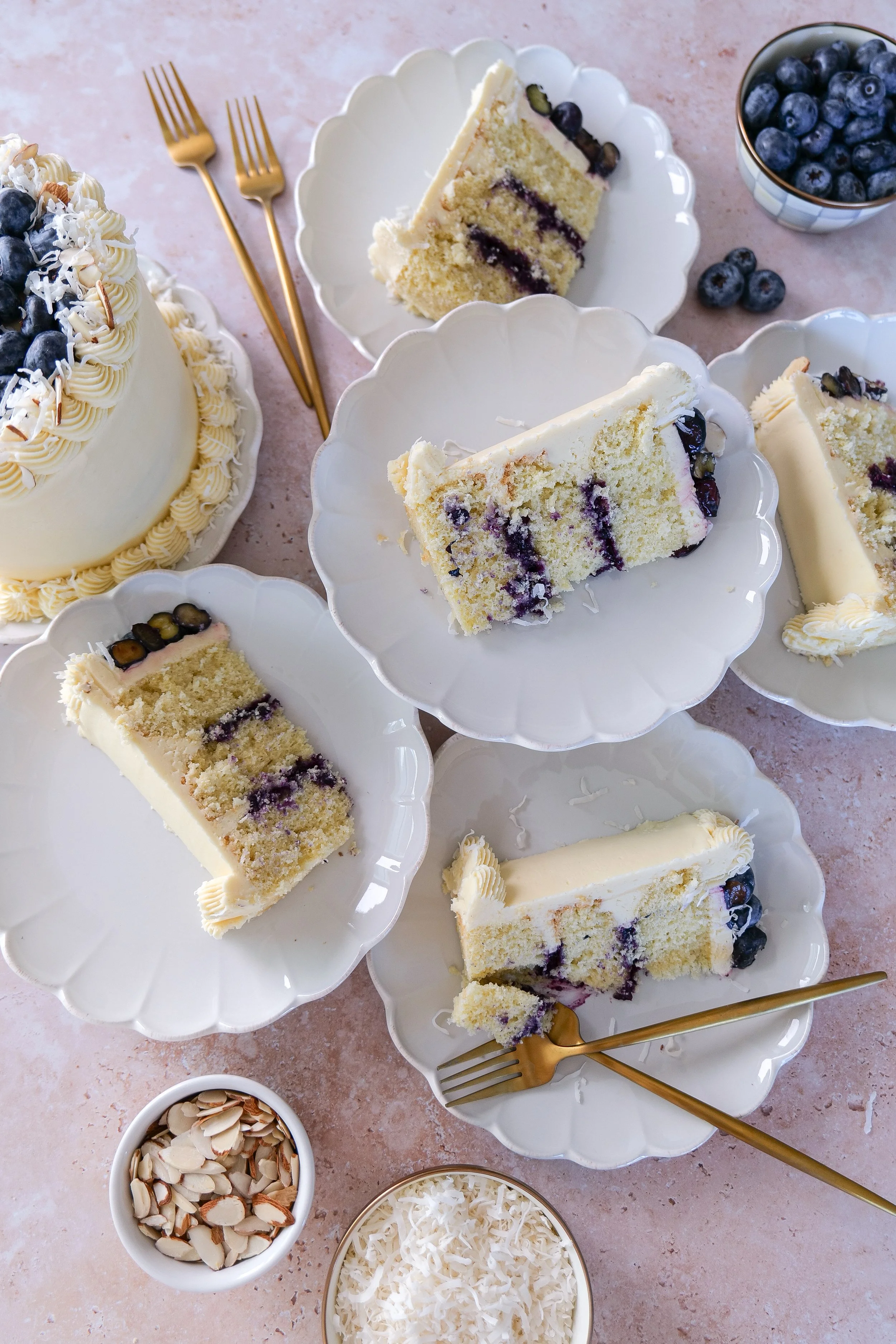 Almond coconut cake with blueberry curd filling and coconut buttercream frosting served as a spring celebration dessert.