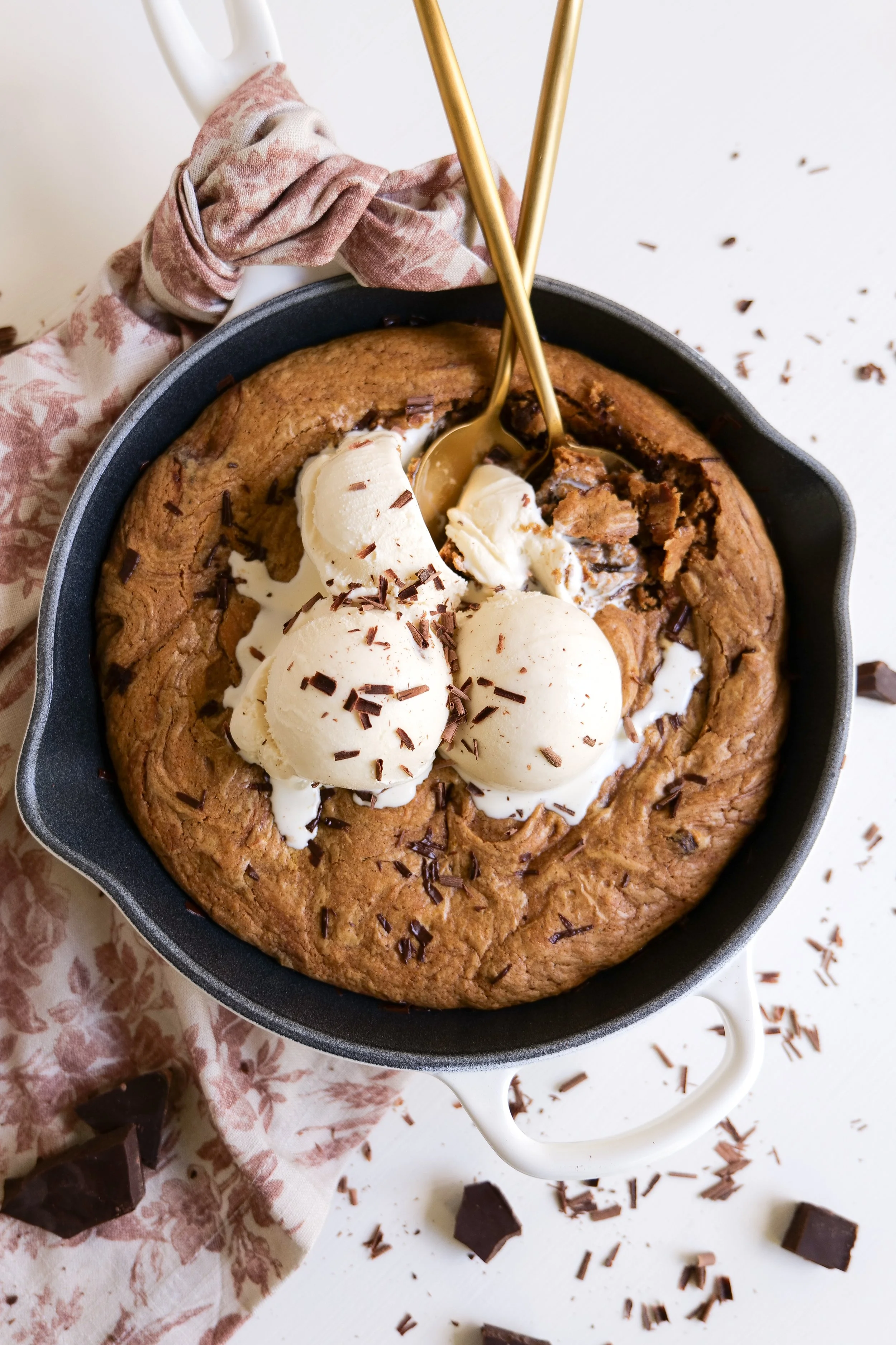 Brown butter pumpkin chocolate chip oatmeal pizookie baked in a skillet and topped with vanilla ice cream