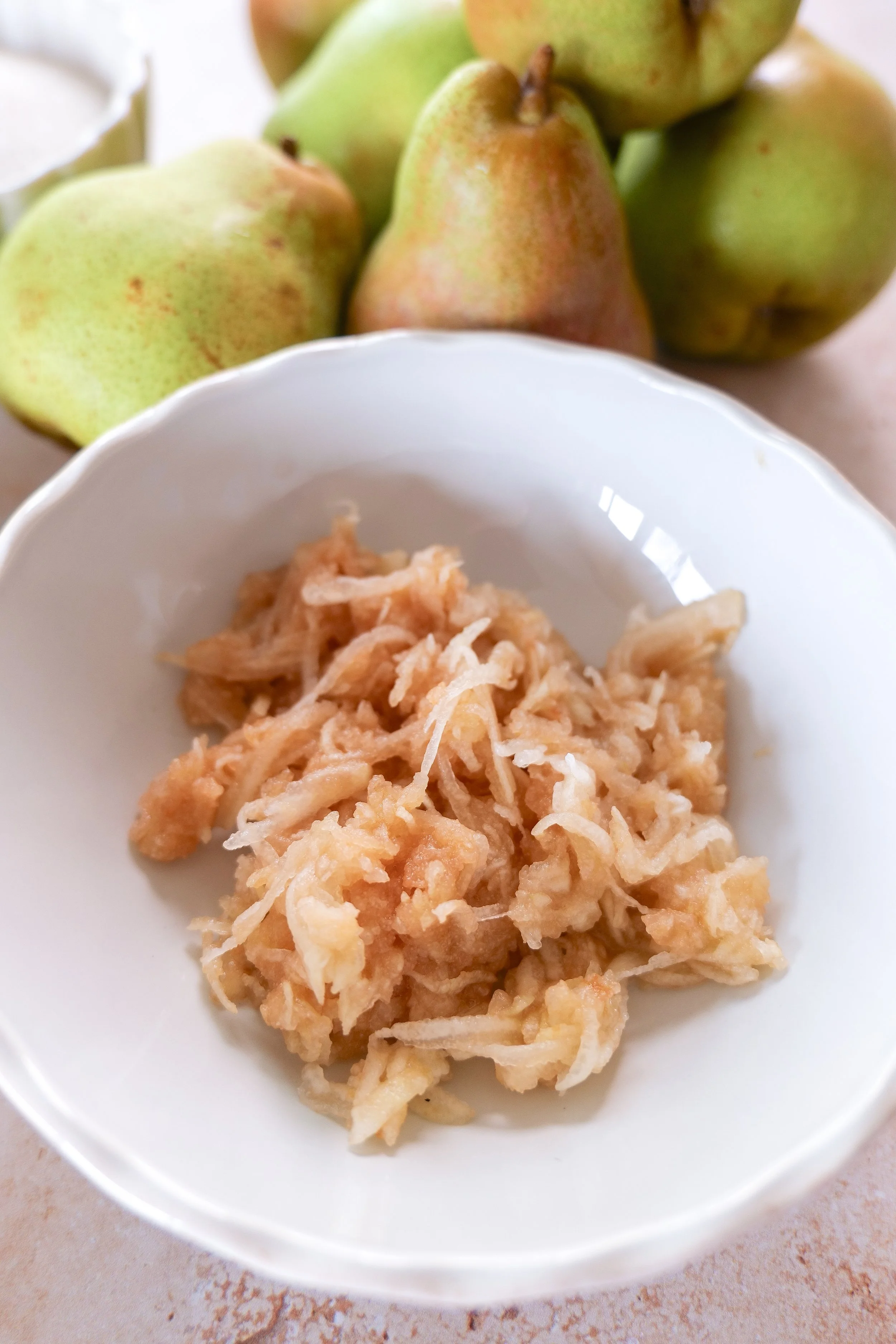 Fresh pear finely grated for homemade pear cake batter.