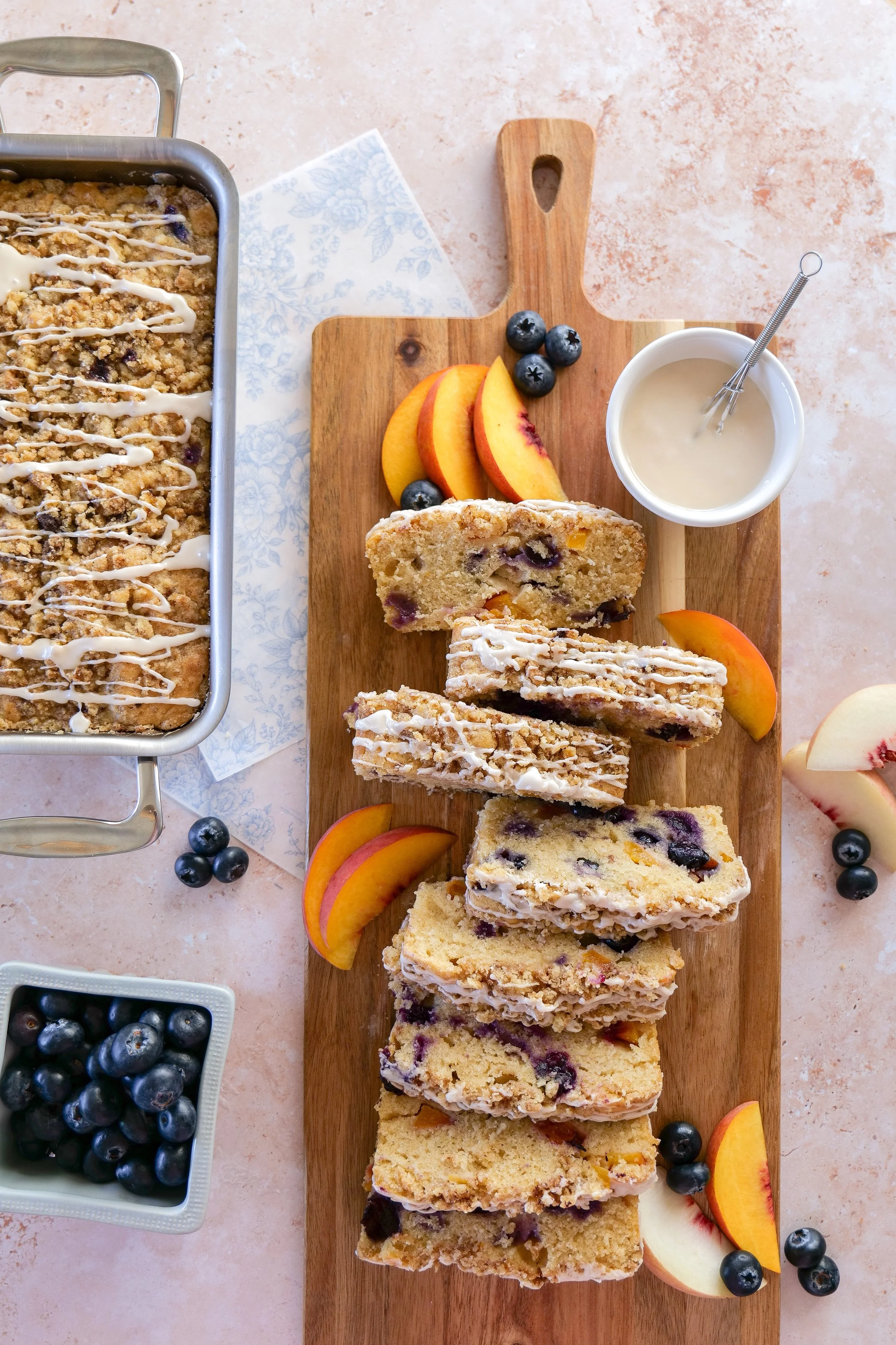 Homemade Blueberry Peach Bread served with coffee and fresh peaches for a summer breakfast.