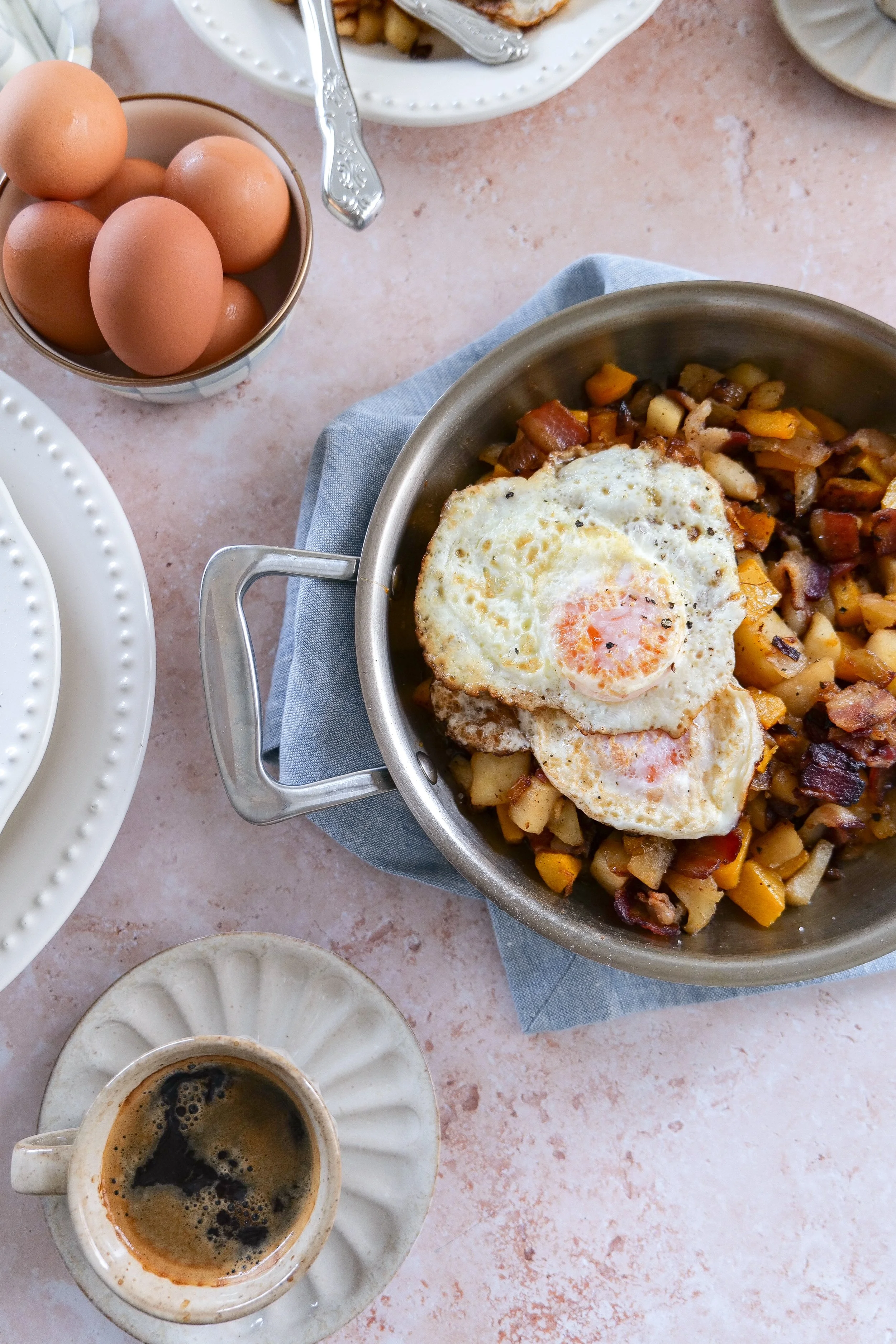 Roasted butternut squash breakfast hash topped with freshly fried eggs.