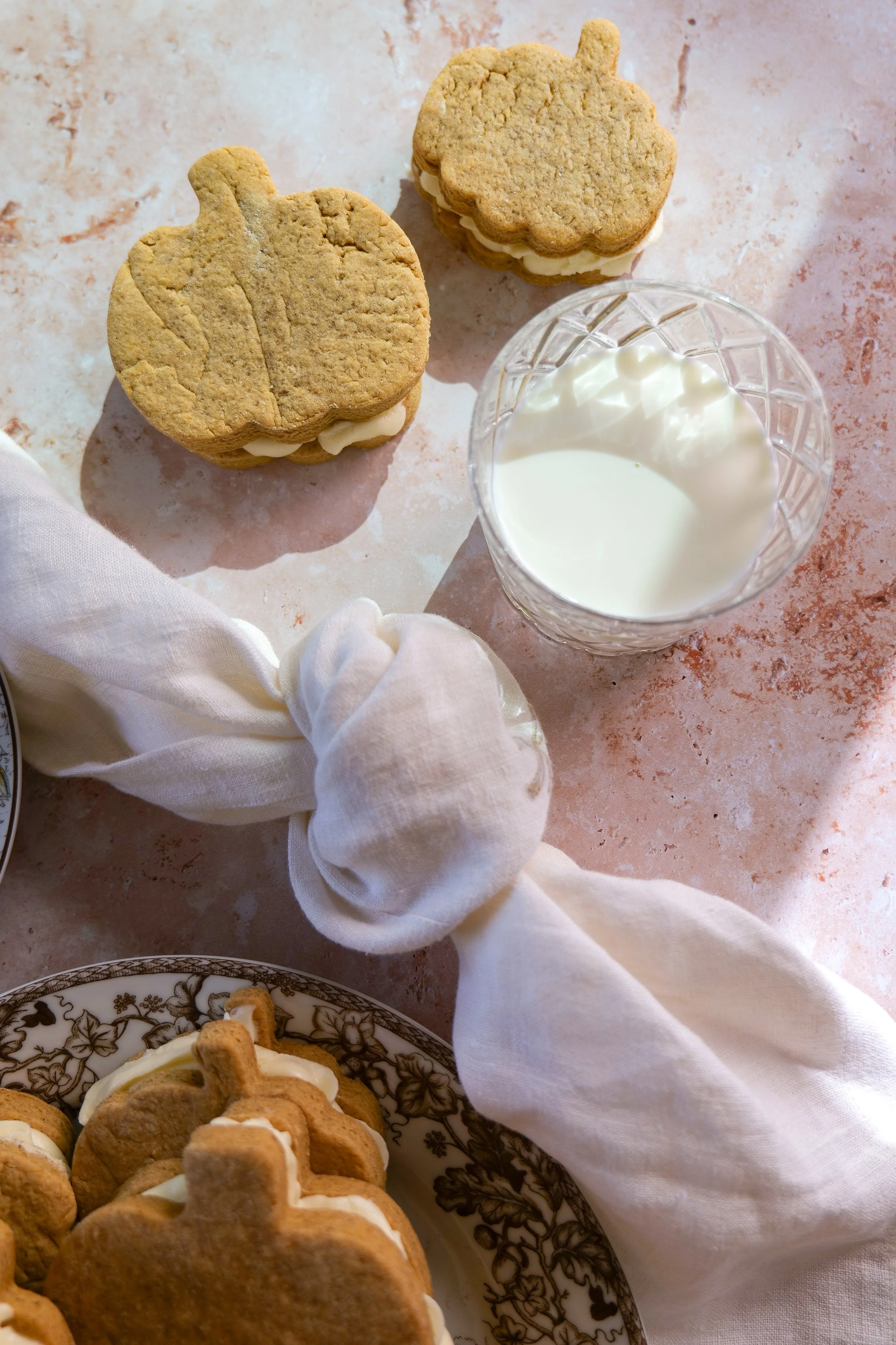 Pumpkin-shaped sandwich cookies filled with vanilla cream cheese filling