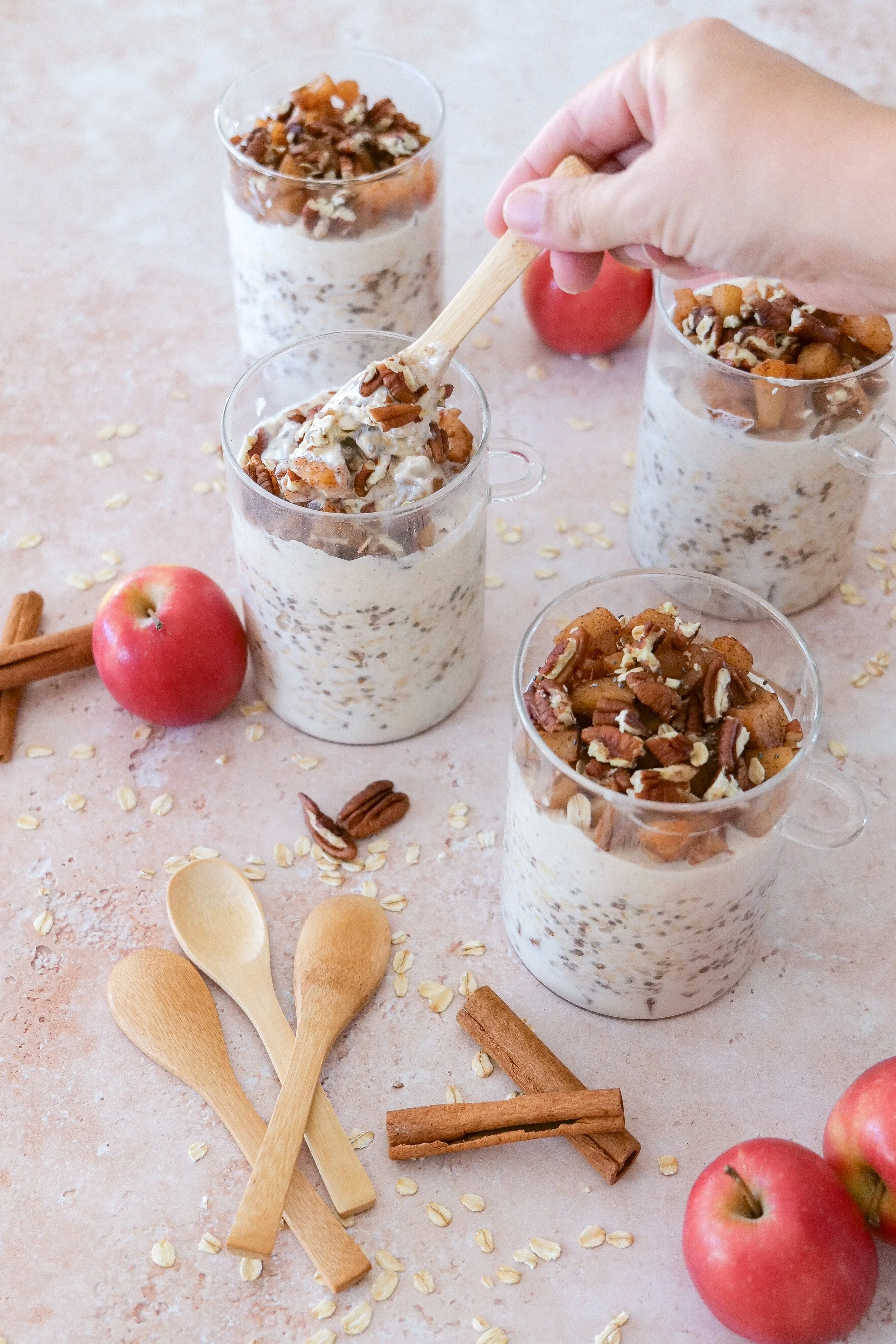 Apple cinnamon overnight oats layered in a glass jar and topped with cooked apples.