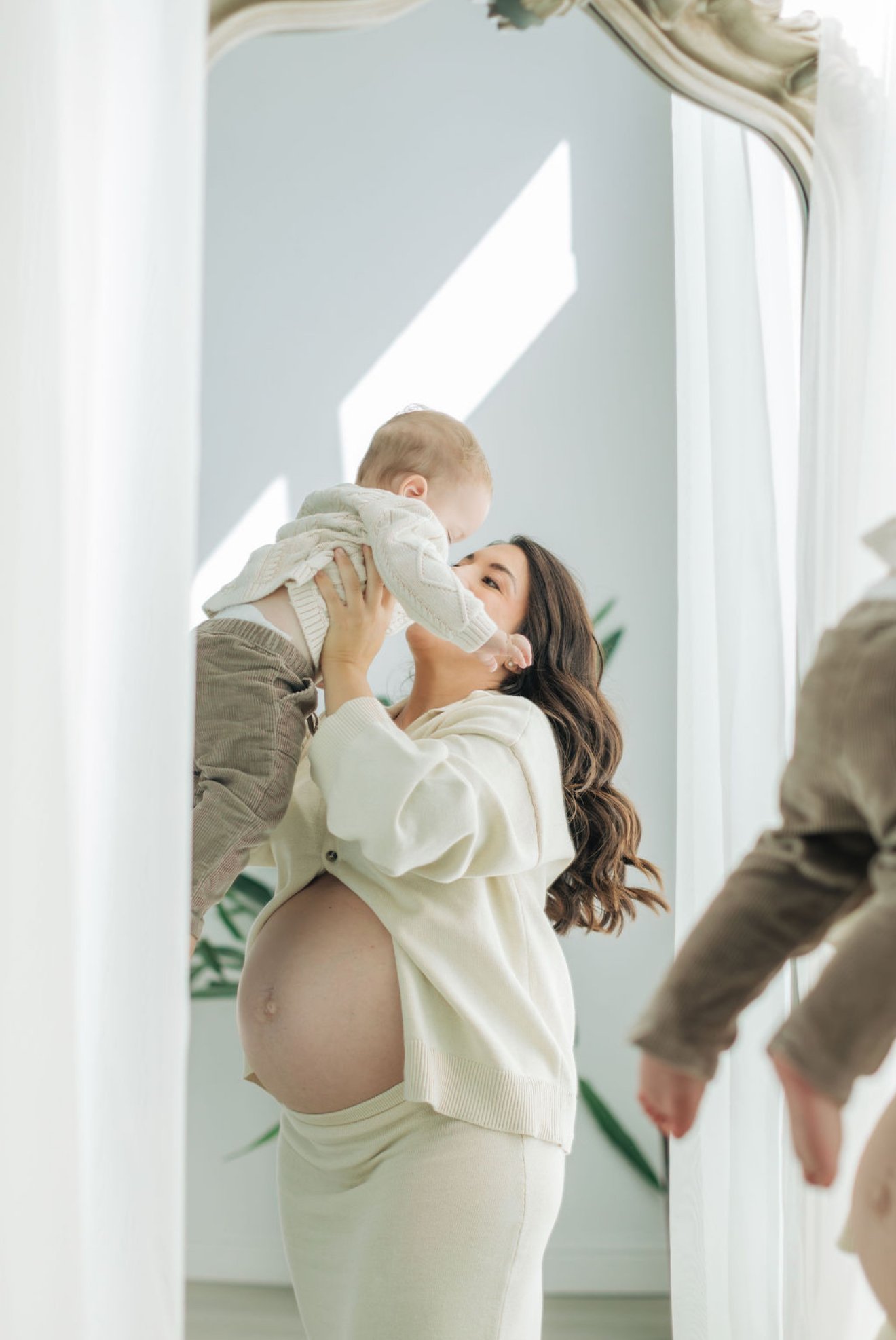 Pregnant mom holding her toddler while preparing for a new baby.