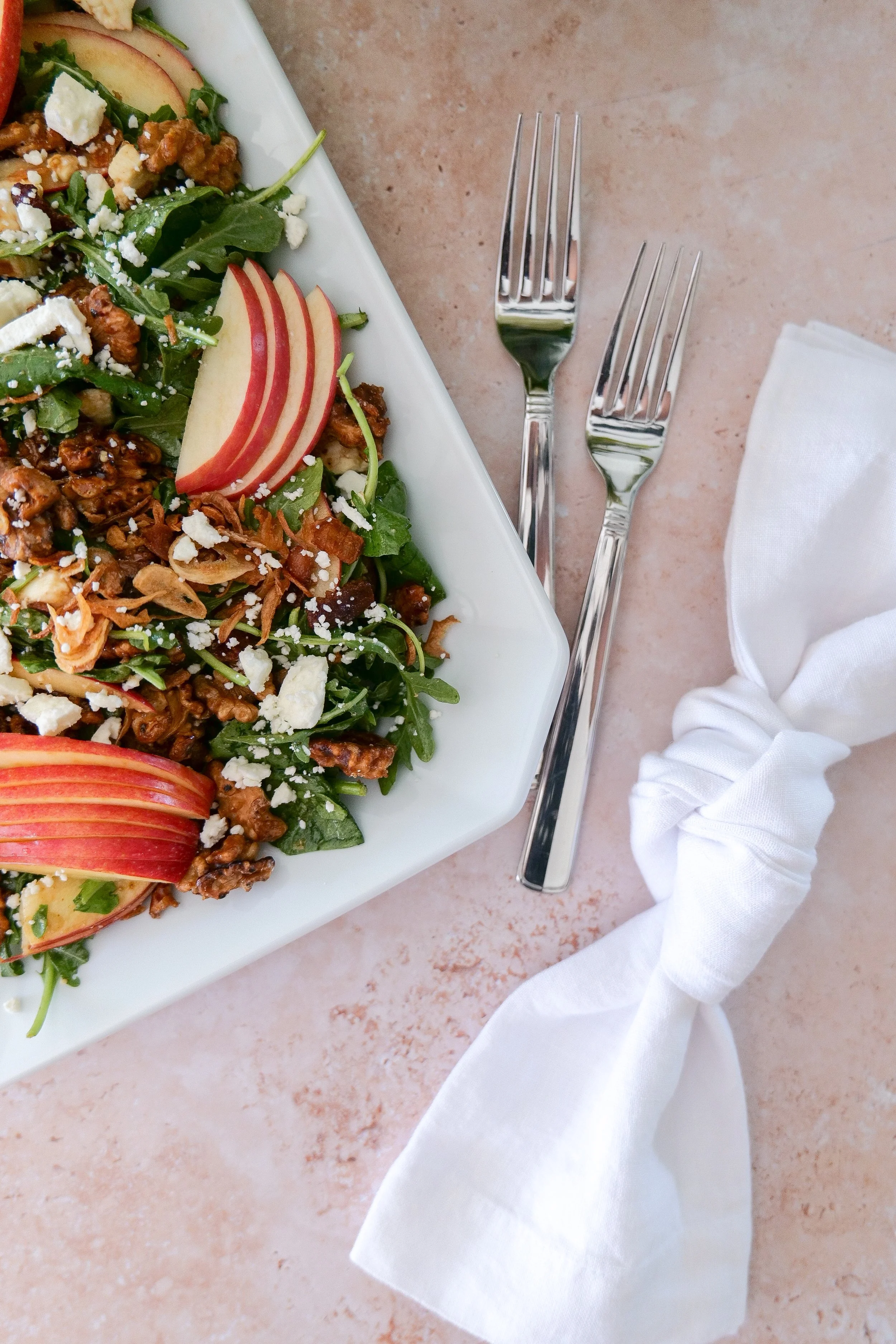 Easy fall salad with thinly sliced apples, bacon, feta, walnuts and crispy shallots.