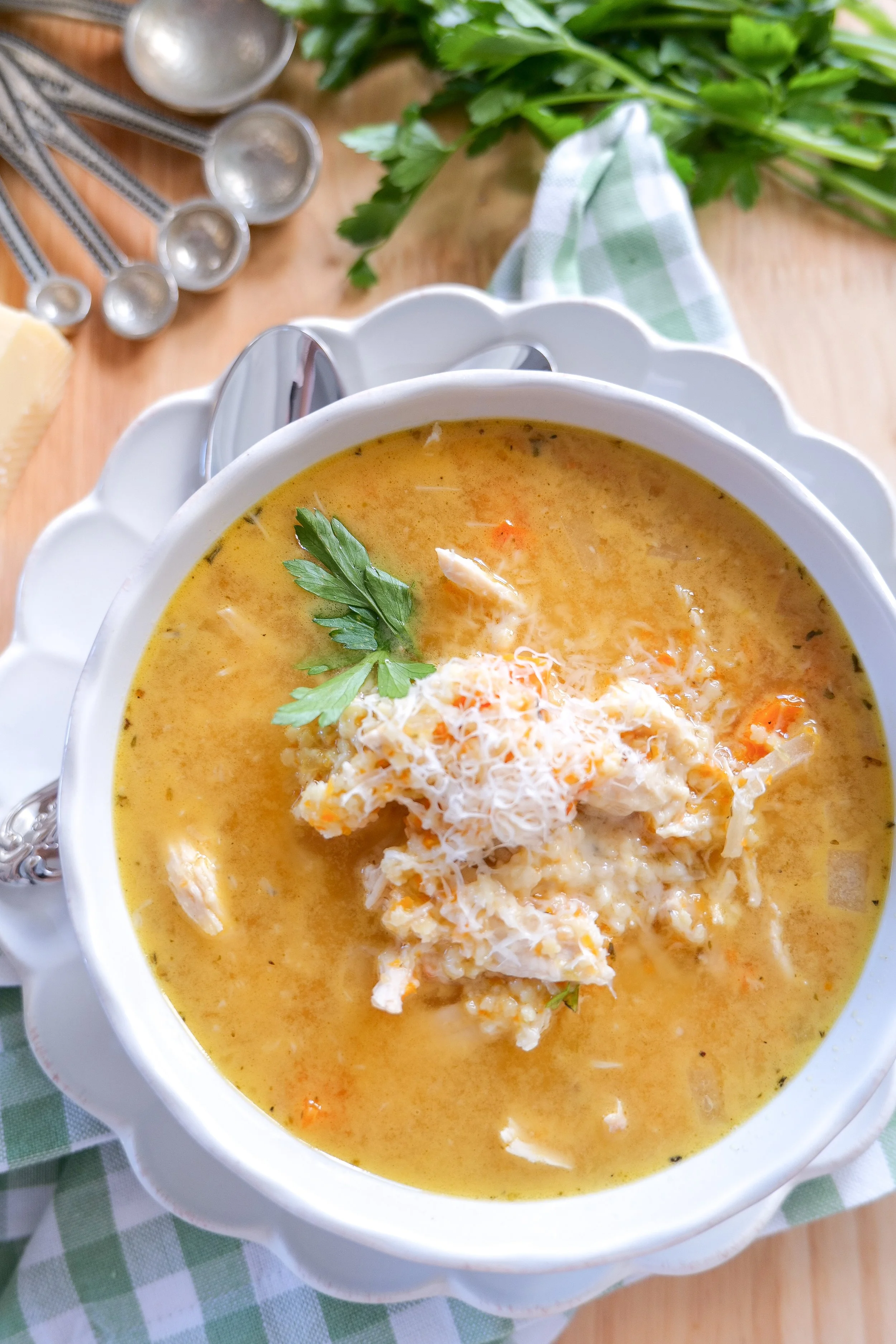 Bowl of slow cooker Italian Penicillin Soup with tender chicken, vegetables, pastina, Parmesan and fresh parsley.