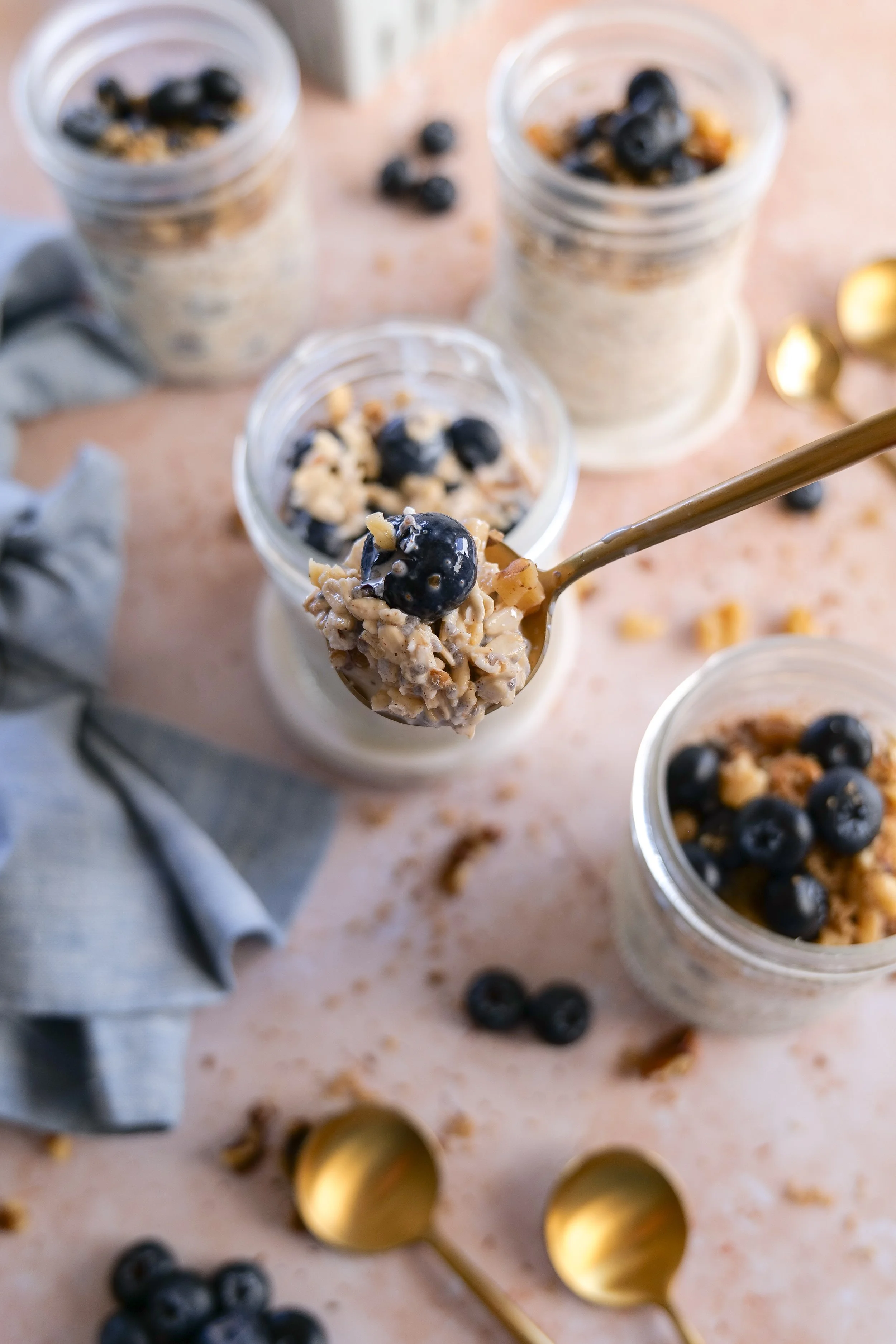 Spoonful of creamy Blueberry Pie Overnight Oats with fresh blueberries.