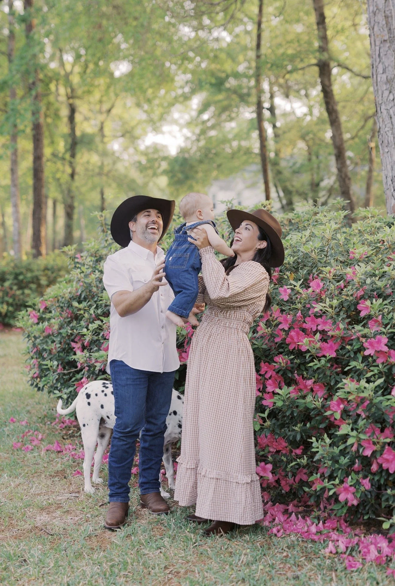Family together in front of blooming pink flowers at their Texas home