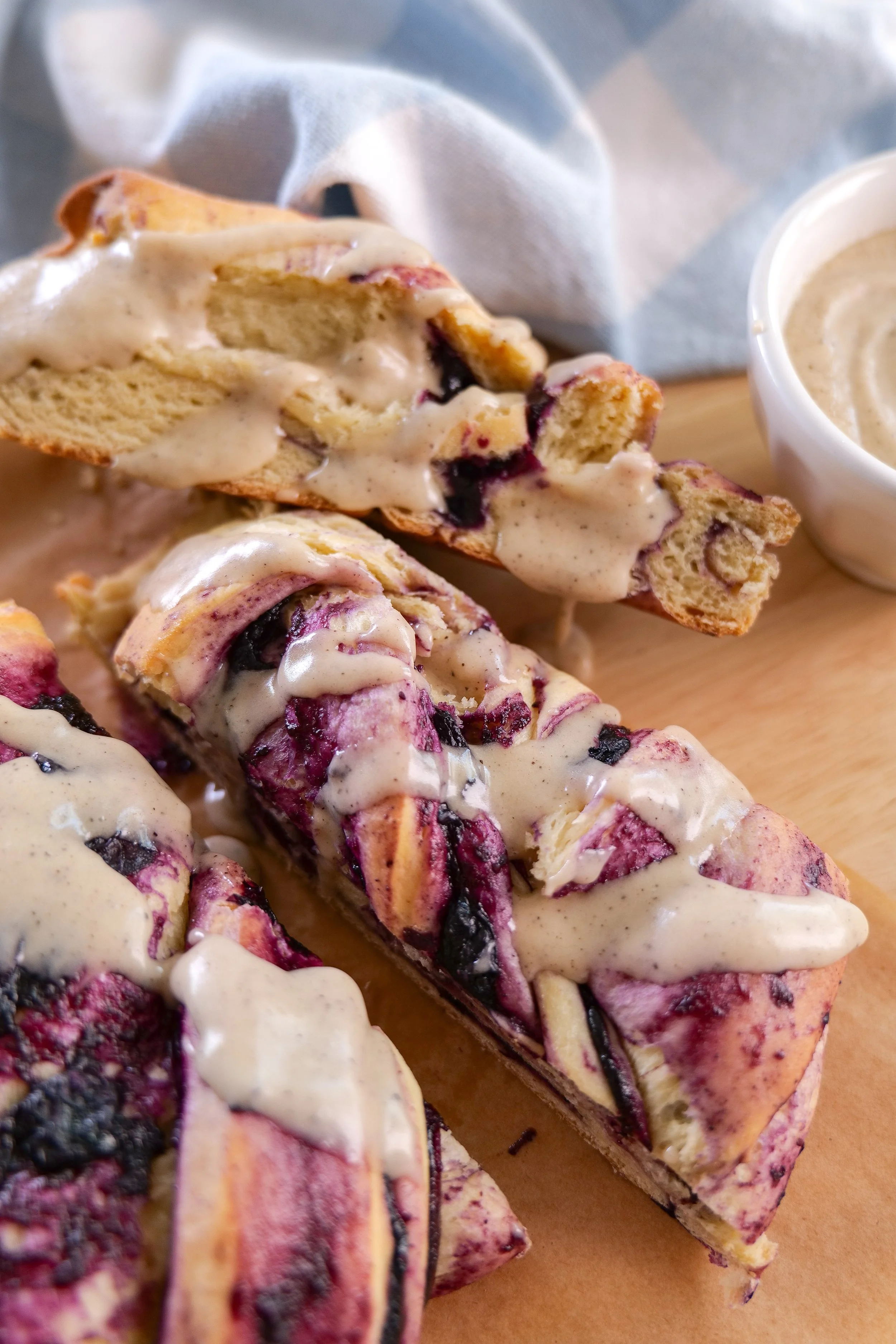 Homemade blueberry cinnamon roll bread with blueberry swirls and sweet brown butter icing.