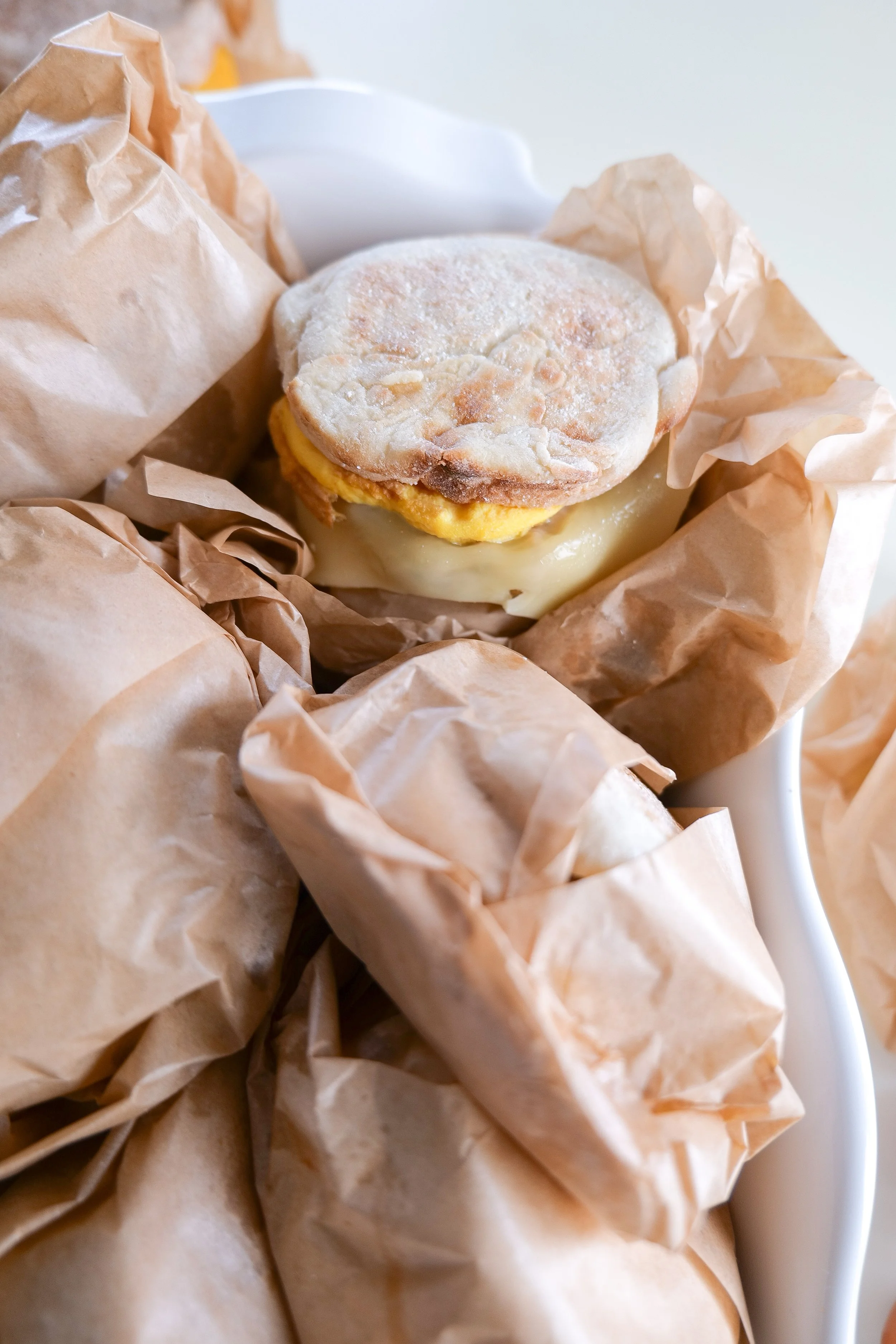 Close-up of a homemade sausage breakfast sandwich with egg and melted cheese.