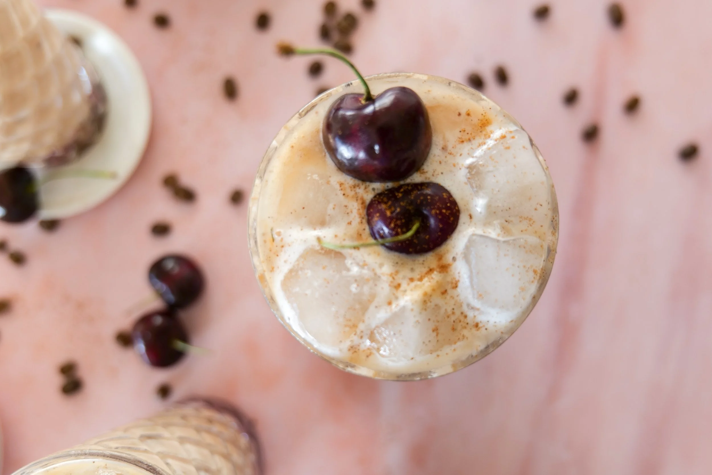 Homemade iced cherry coffee drink with espresso, milk, and whipped cherry cold foam.