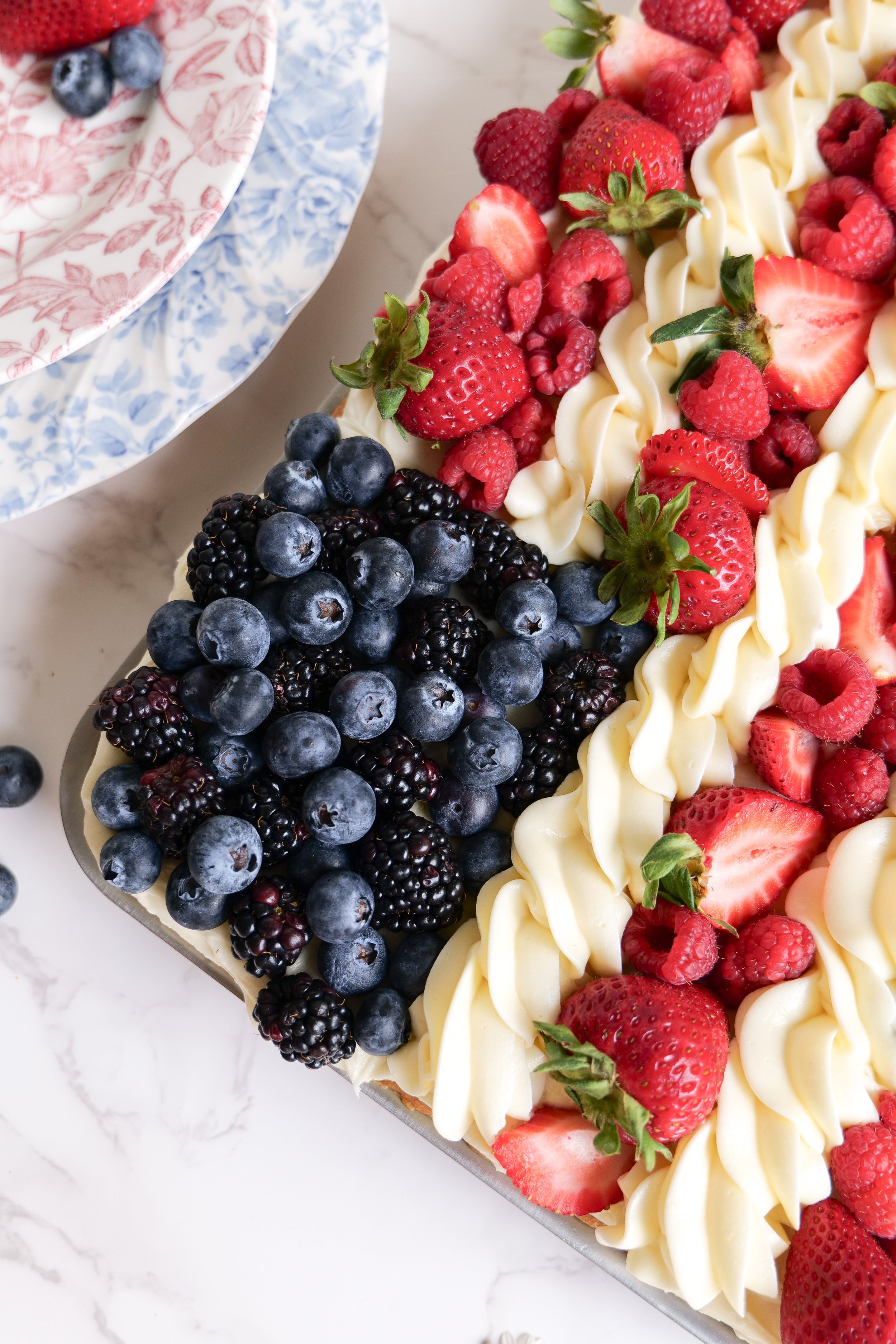 Red white and blue fruit pizza made with strawberries blueberries and sugar cookie dough