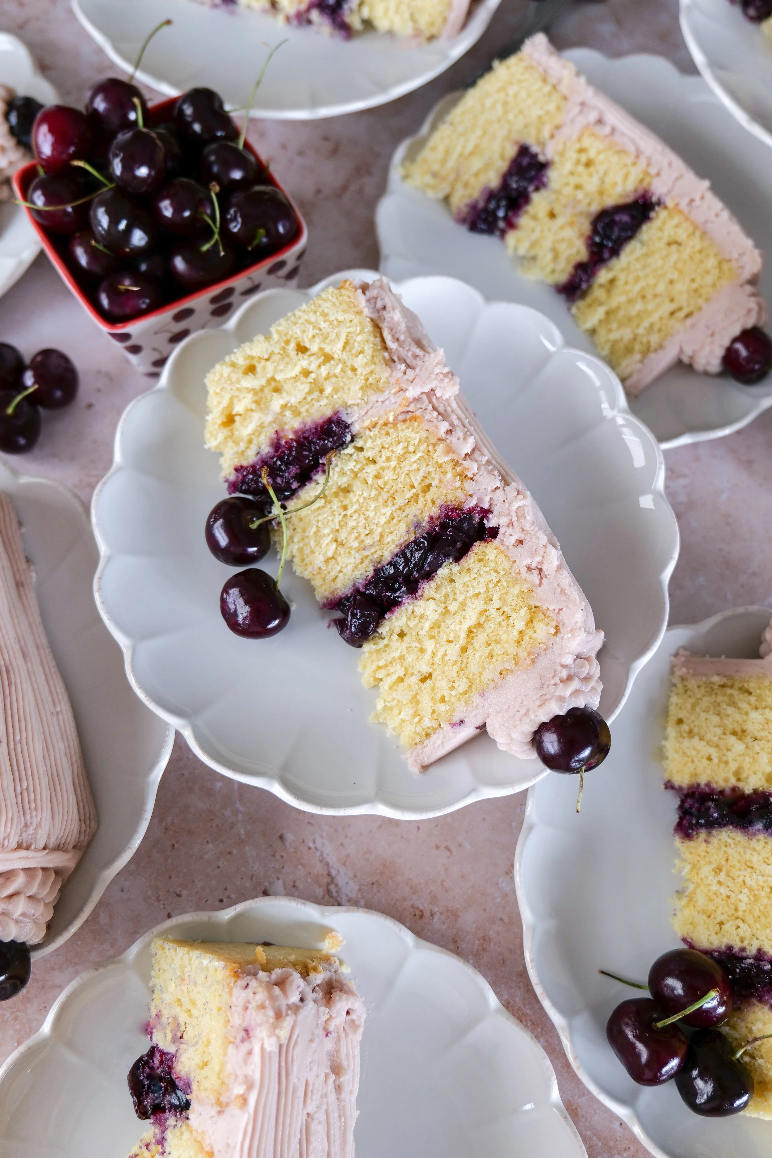 Several slices of vanilla bean cherry cake styled for summer entertaining and celebrations.