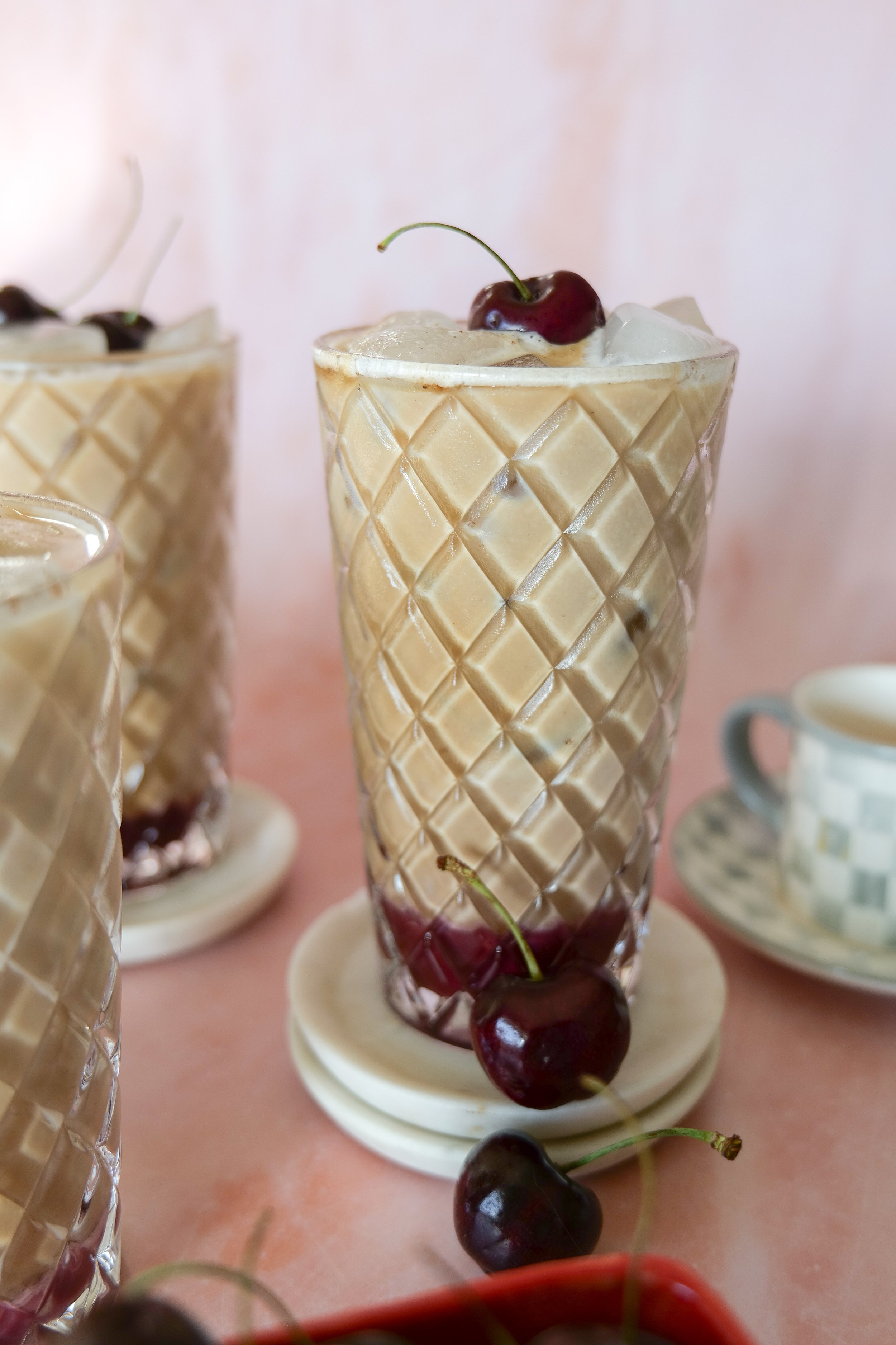 Refreshing summer iced cherry latte topped with cherry cold foam and homemade cherry cobbler syrup.