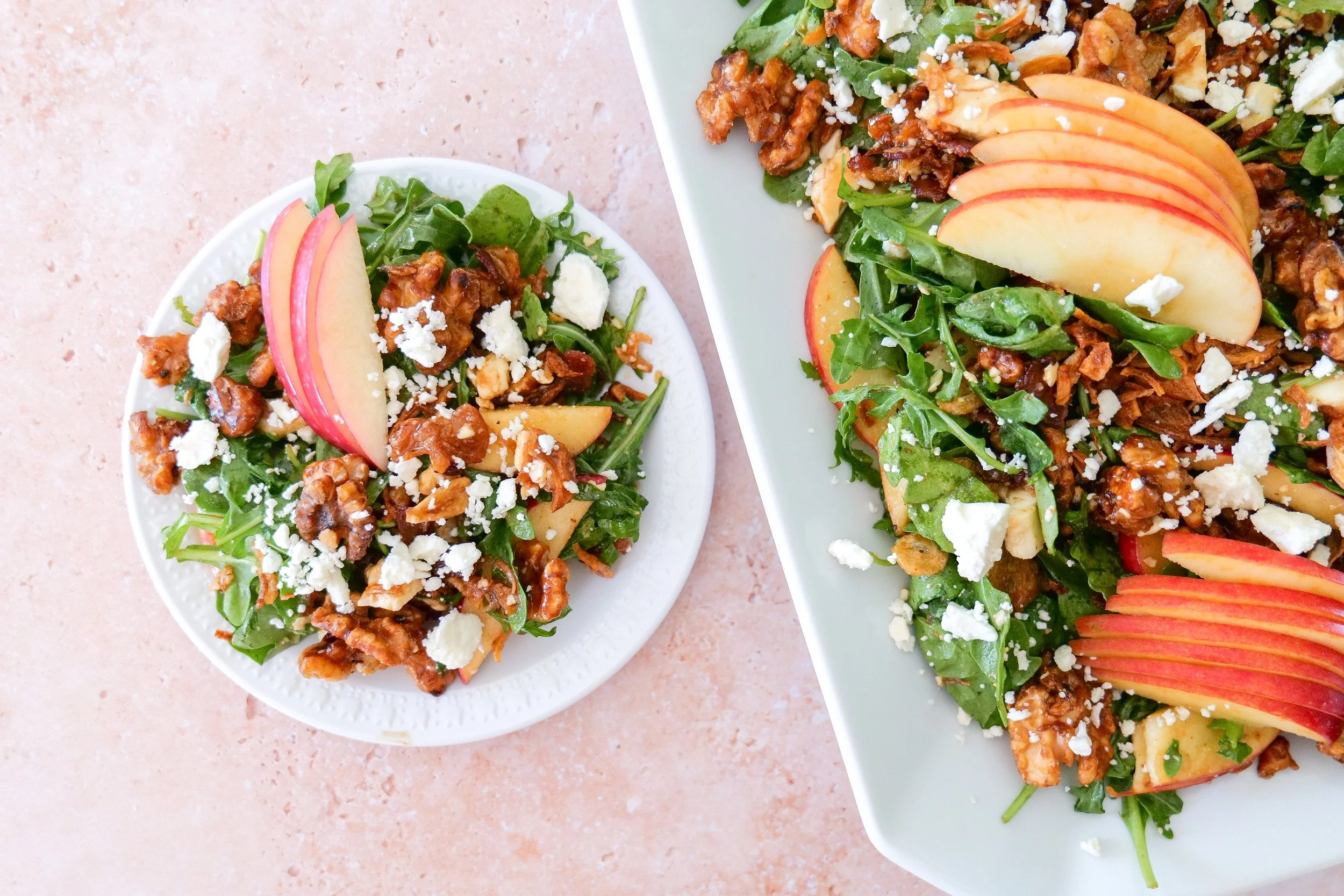 Spinach and arugula fall salad topped with apples, feta, bacon and maple walnuts.