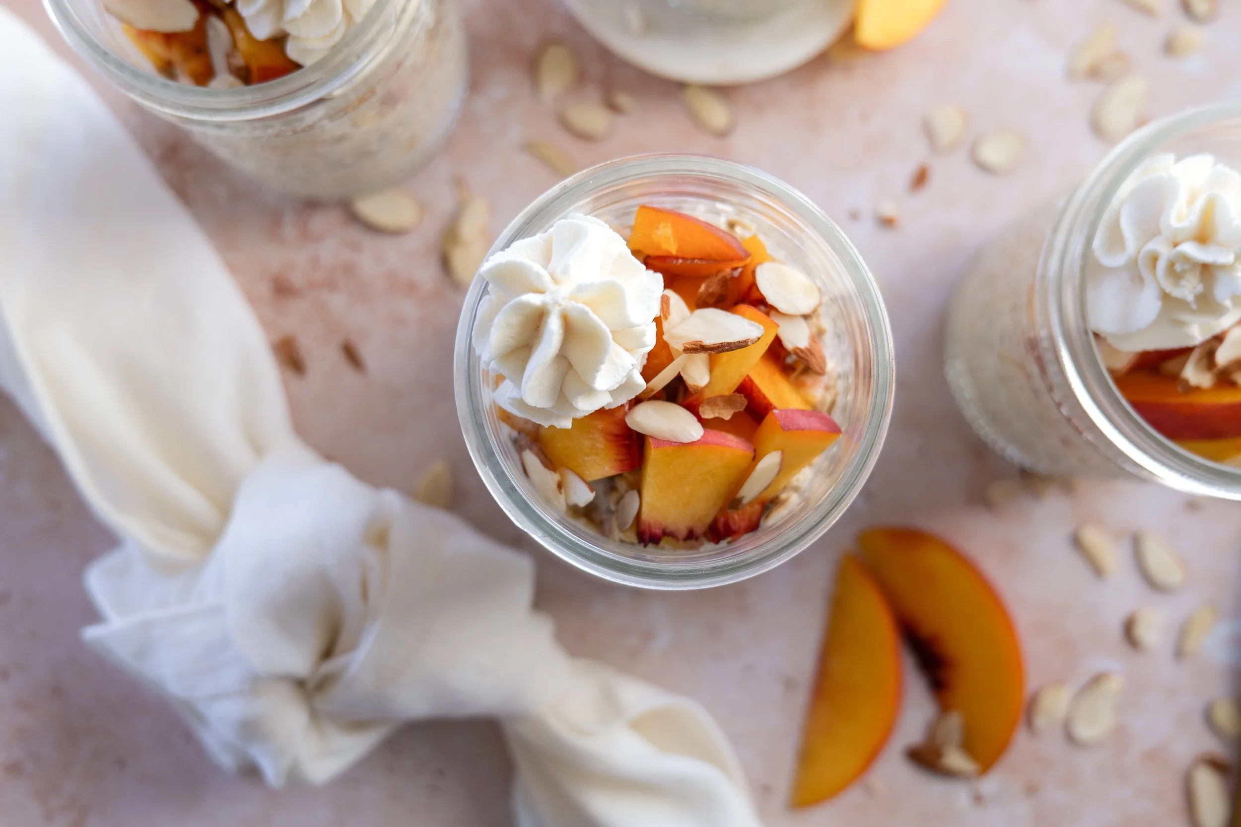 Meal prep jars filled with Peach Cobbler Overnight Oats ready for the week.