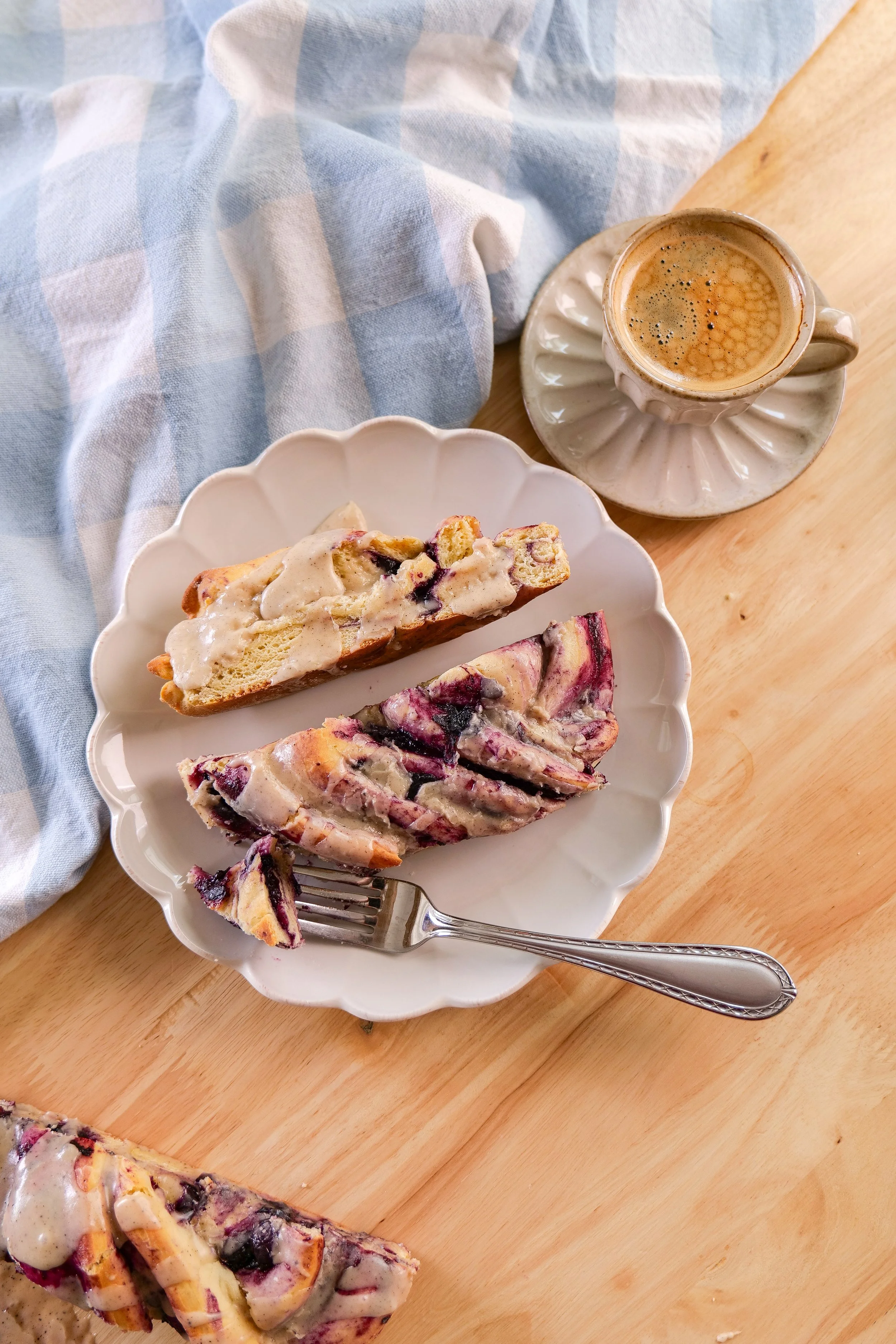 Soft blueberry cinnamon roll bread with layers of homemade blueberry filling and vanilla brown butter icing.