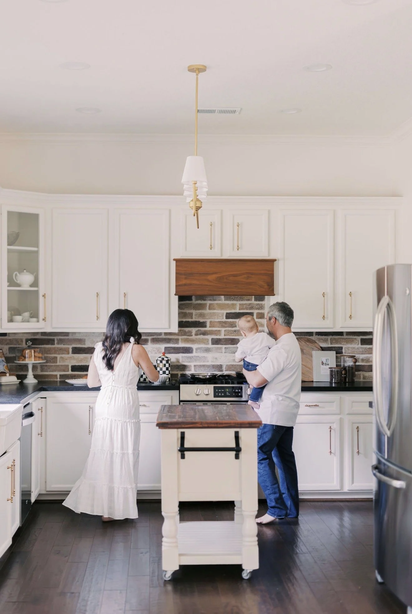 Family together in the kitchen with their backs to the camera during everyday life in their Texas home