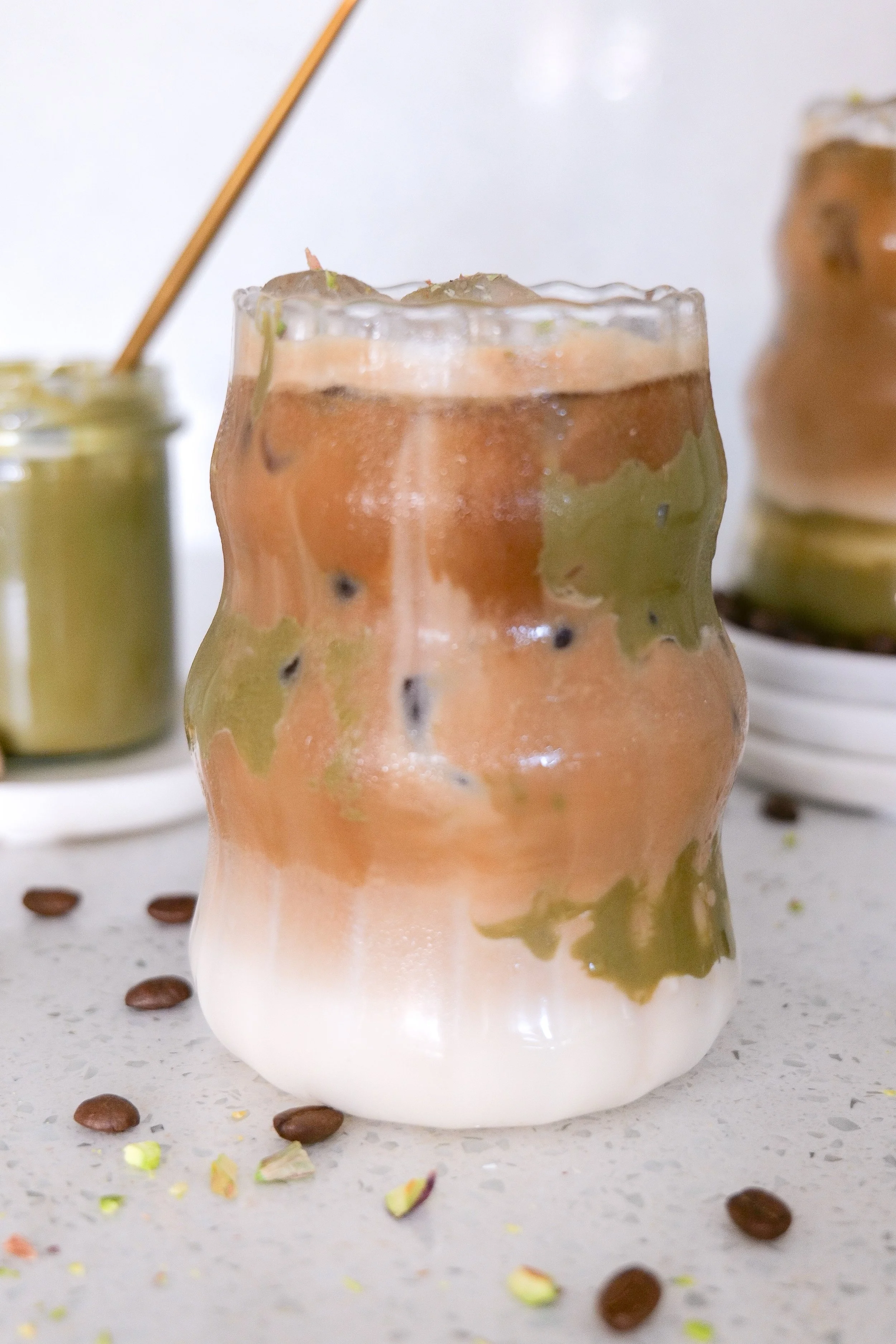 Iced pistachio latte with fresh espresso poured over creamy milk.
