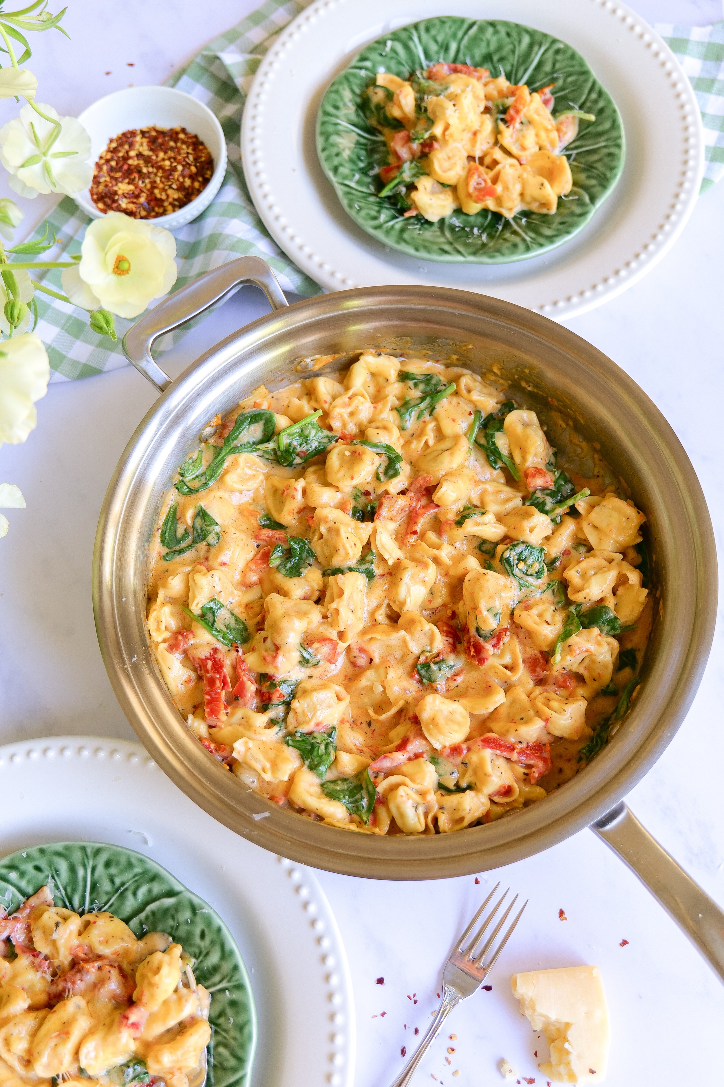 One Pot Marry Me Tortellini with spinach and tomatoes being served warm at the table