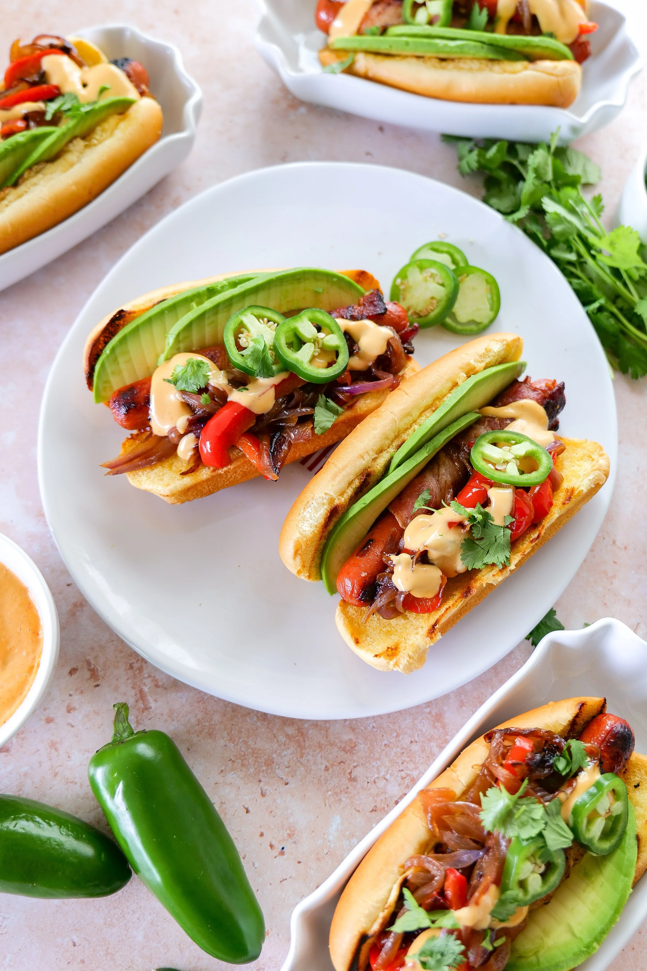 Bacon-wrapped hot dogs topped with fresh garnishes