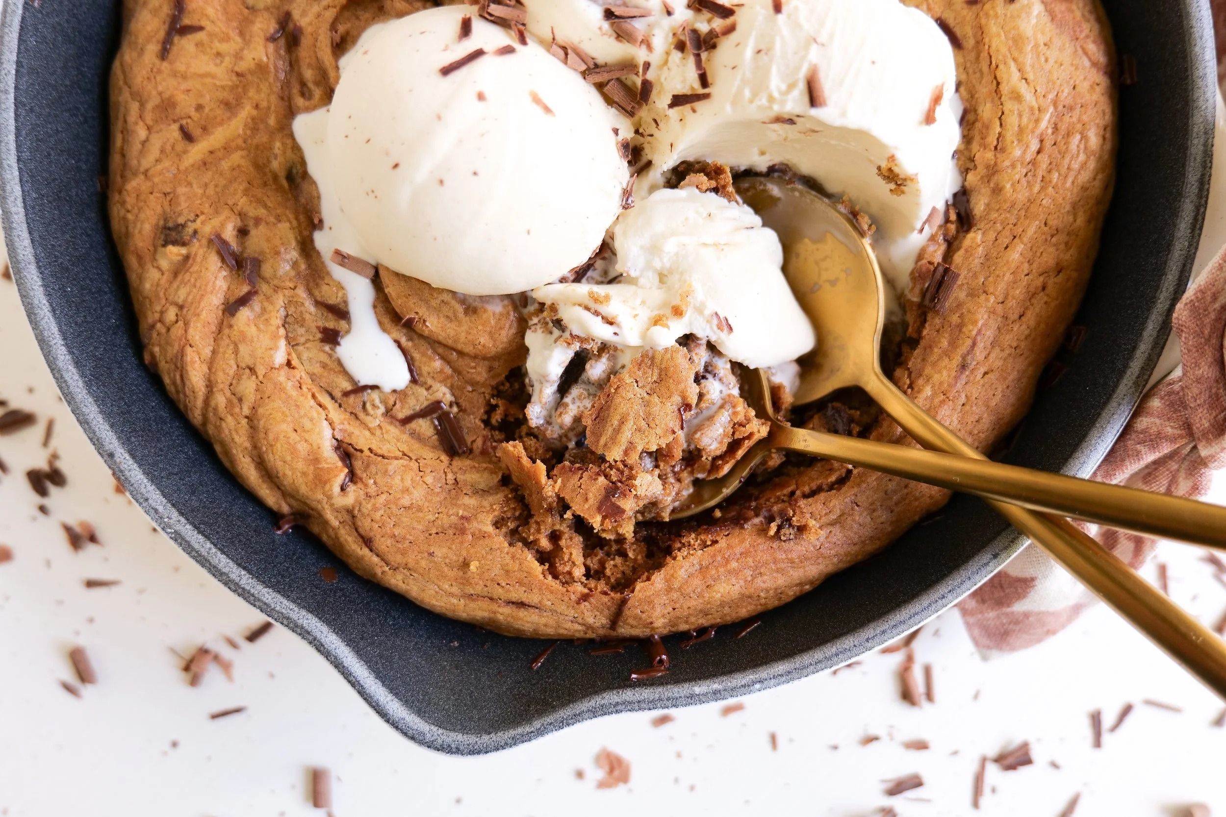 Warm pumpkin chocolate chip pizookie topped with scoops of vanilla ice cream