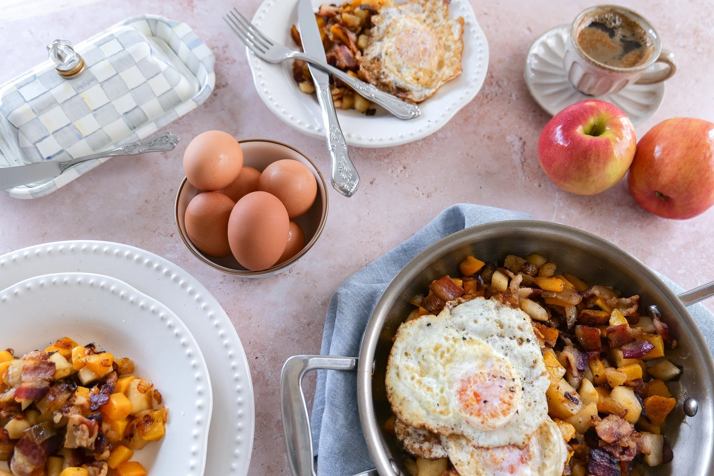 Homemade butternut squash hash with sweet apples, crispy bacon, onions, and fried eggs.