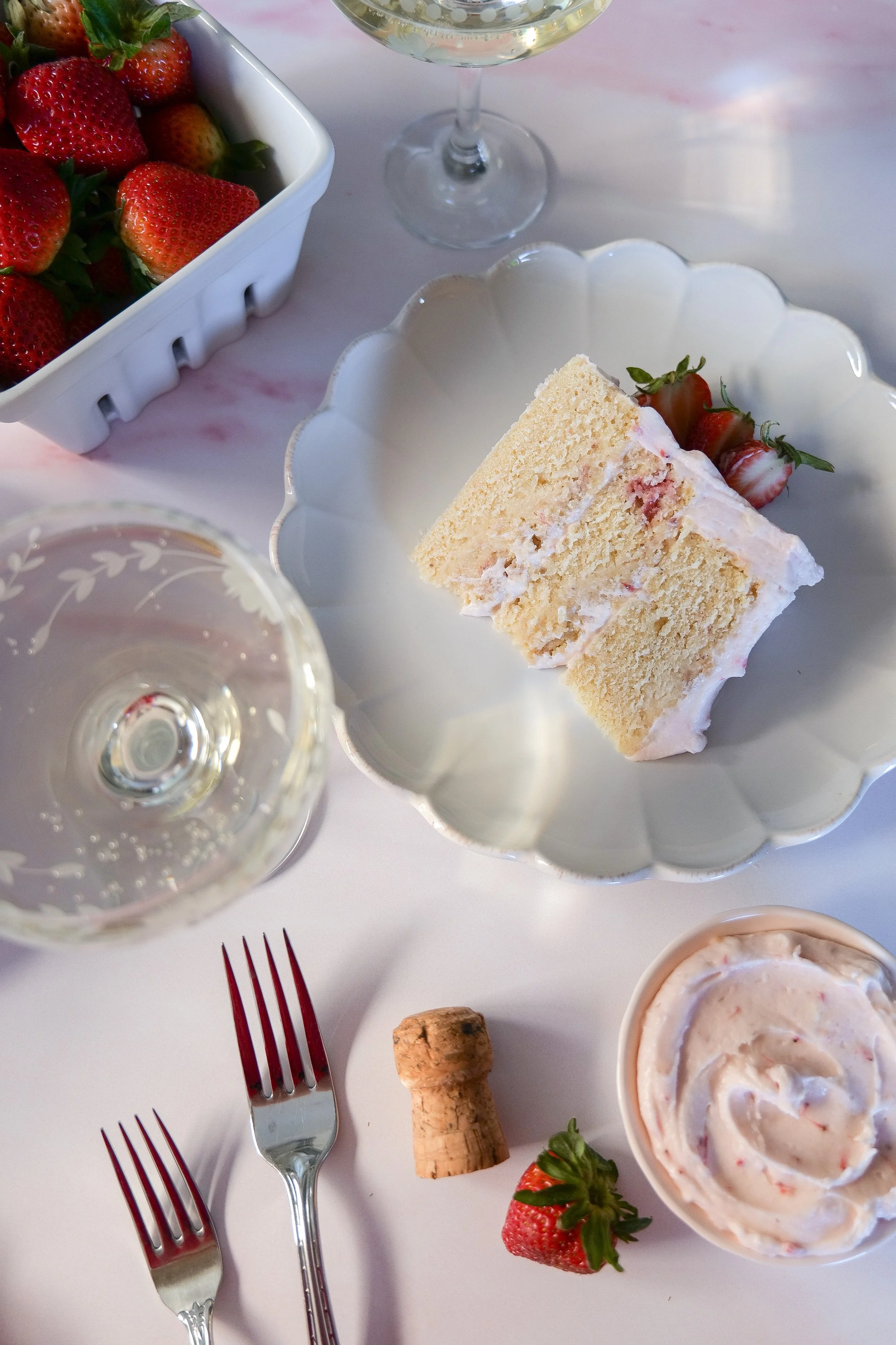 Pink strawberry champagne layer cake with a softly frosted exterior.