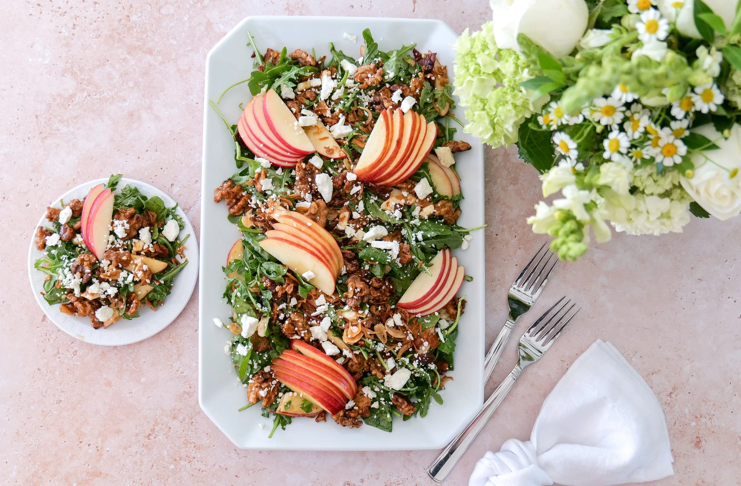 Fall salad with crisp sliced apples, crumbled feta, bacon and maple-glazed walnuts.