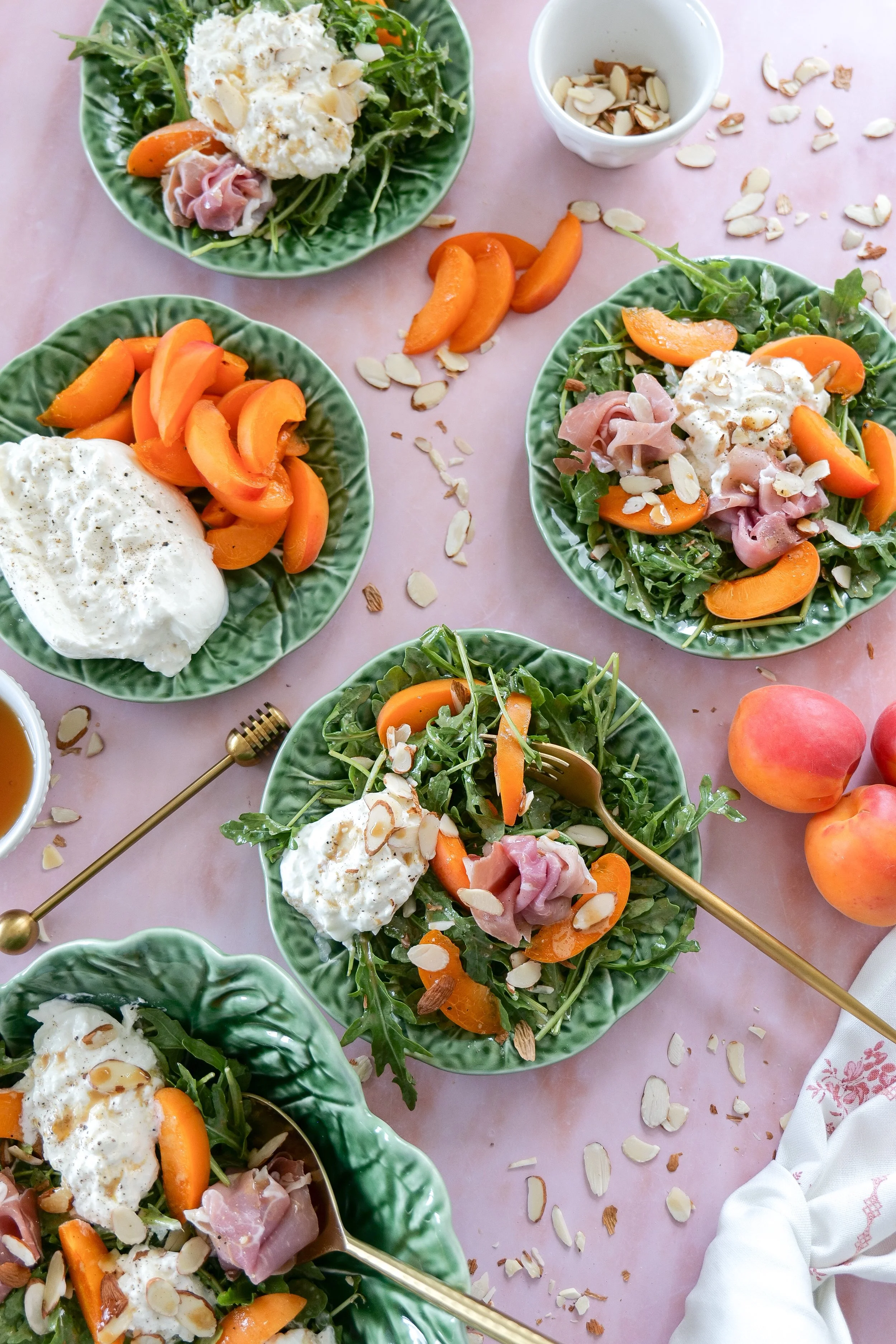 Homemade burrata arugula salad topped with fresh apricots.